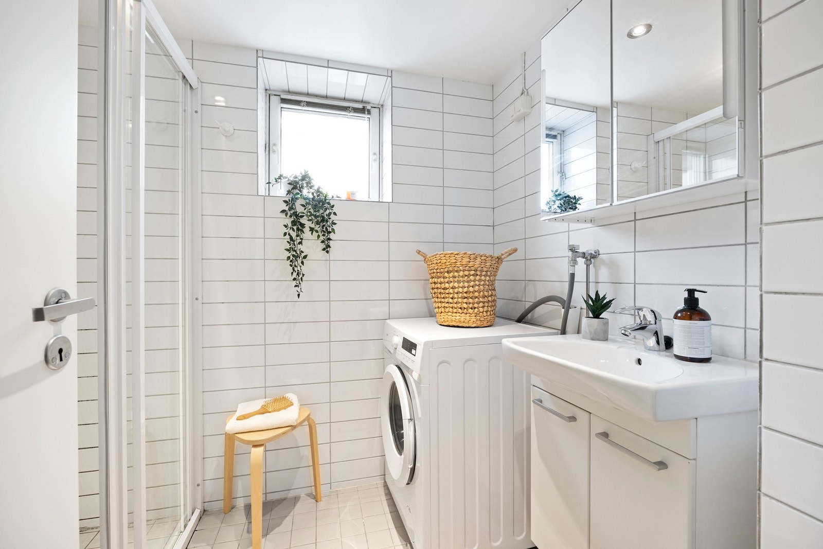 Flislagt baderom fra ca. 2011 med servant, dusj, veggskap og opplegg for vaskemaskin. Galleribilde