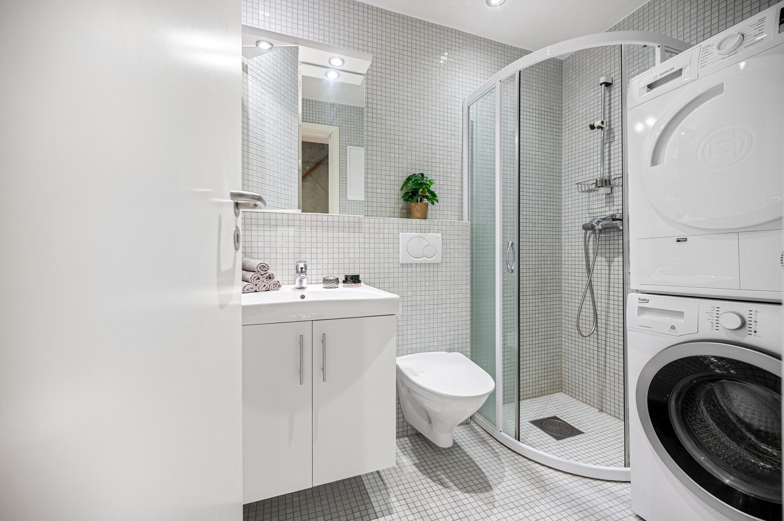 Badet er helfliset med opplegg for vaskemaskin og tørketrommel Galleribilde