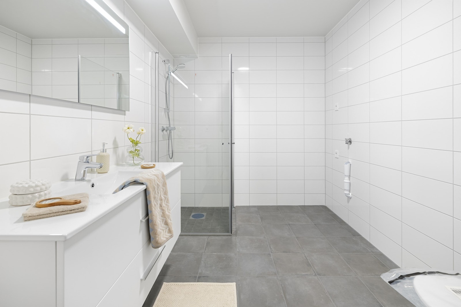 Flott helfliset bad med vegghengt toalett, dusjhjørne og opplegg for vaskemaskin og tørketrommel Galleribilde