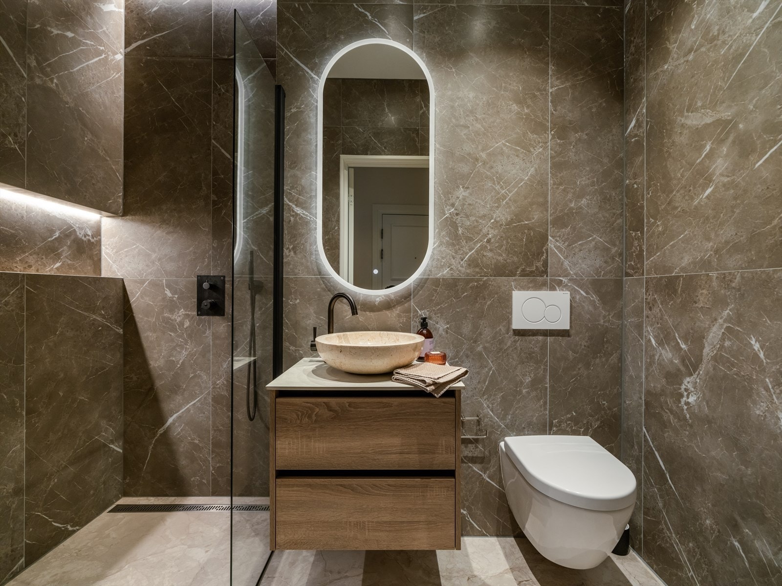 Strøkent og gjennomført baderom fra 2024 med behagelig belysning og gulvvarme. Galleribilde