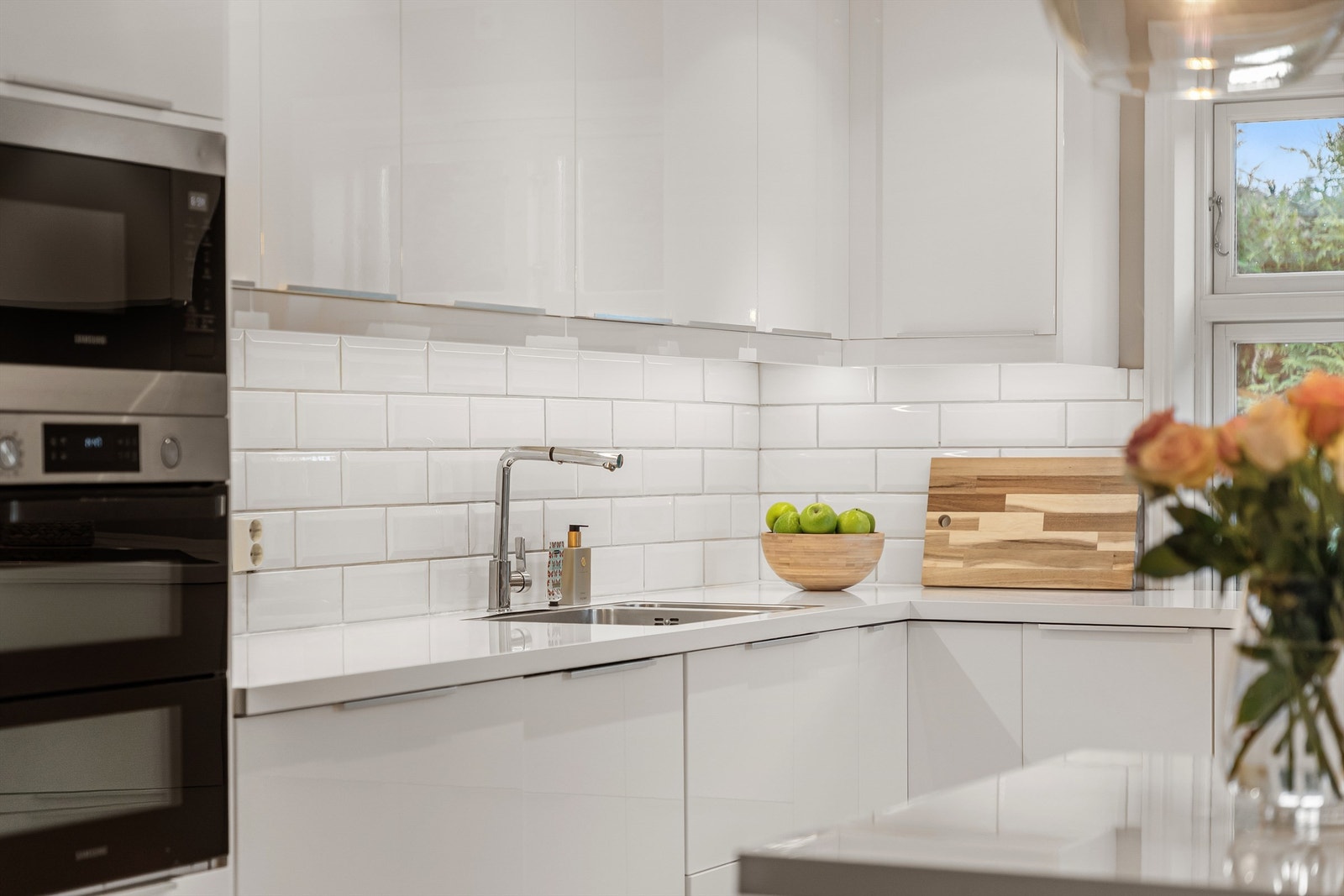 Pent hvitt kjøkken med integrerte hvitevarer Galleribilde