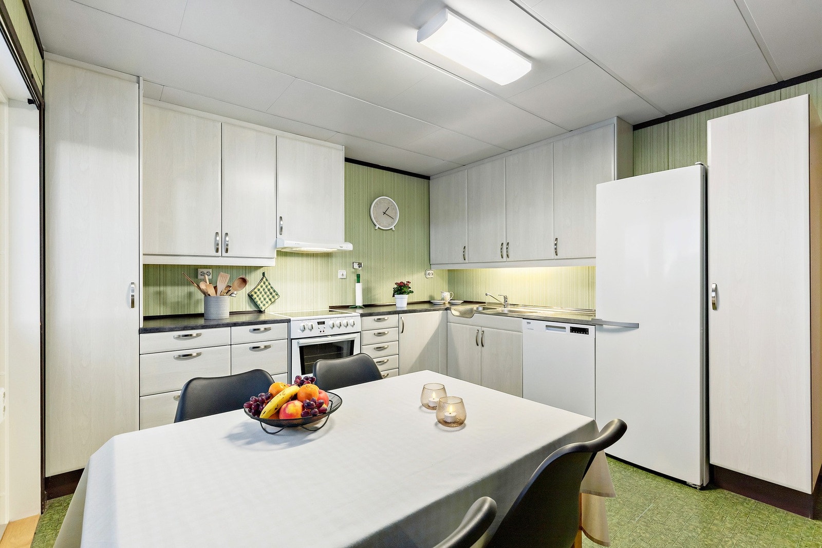 Kjøkken med mekanisk avtrekksvifte over stekesonen og opplegg for oppvaskmaskin. Galleribilde