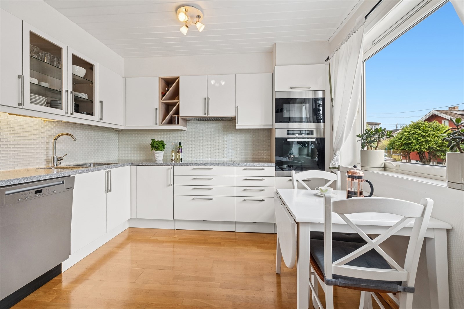 Kjøkkeninnredning med glatte fronter og benkeplate av kompositt. Galleribilde