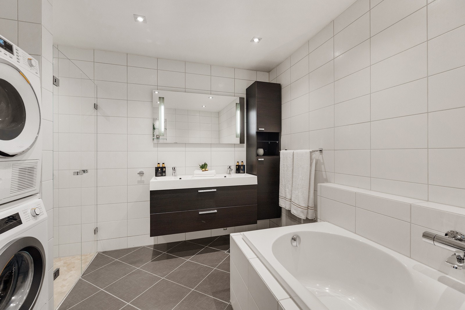 Flislagt baderom fra 2009/2010 med varmekabler. Innredning med nedfelt servant, veggmontert toalett, dusjvegger/hjørne og opplegg for vaskemaskin. Galleribilde