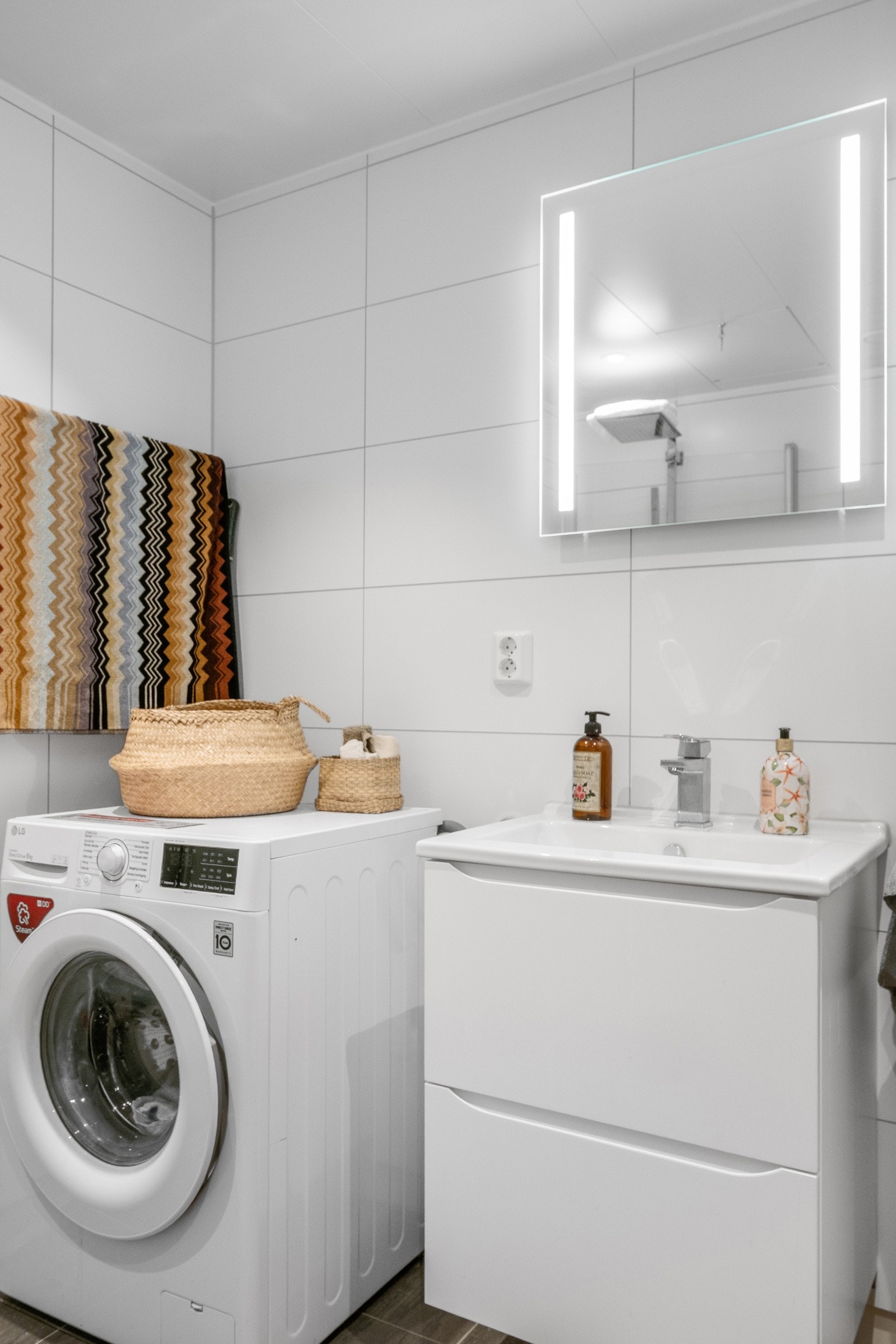 Baderomsinnredning med skuffer, høyskap og heldekkende servantplate. Galleribilde