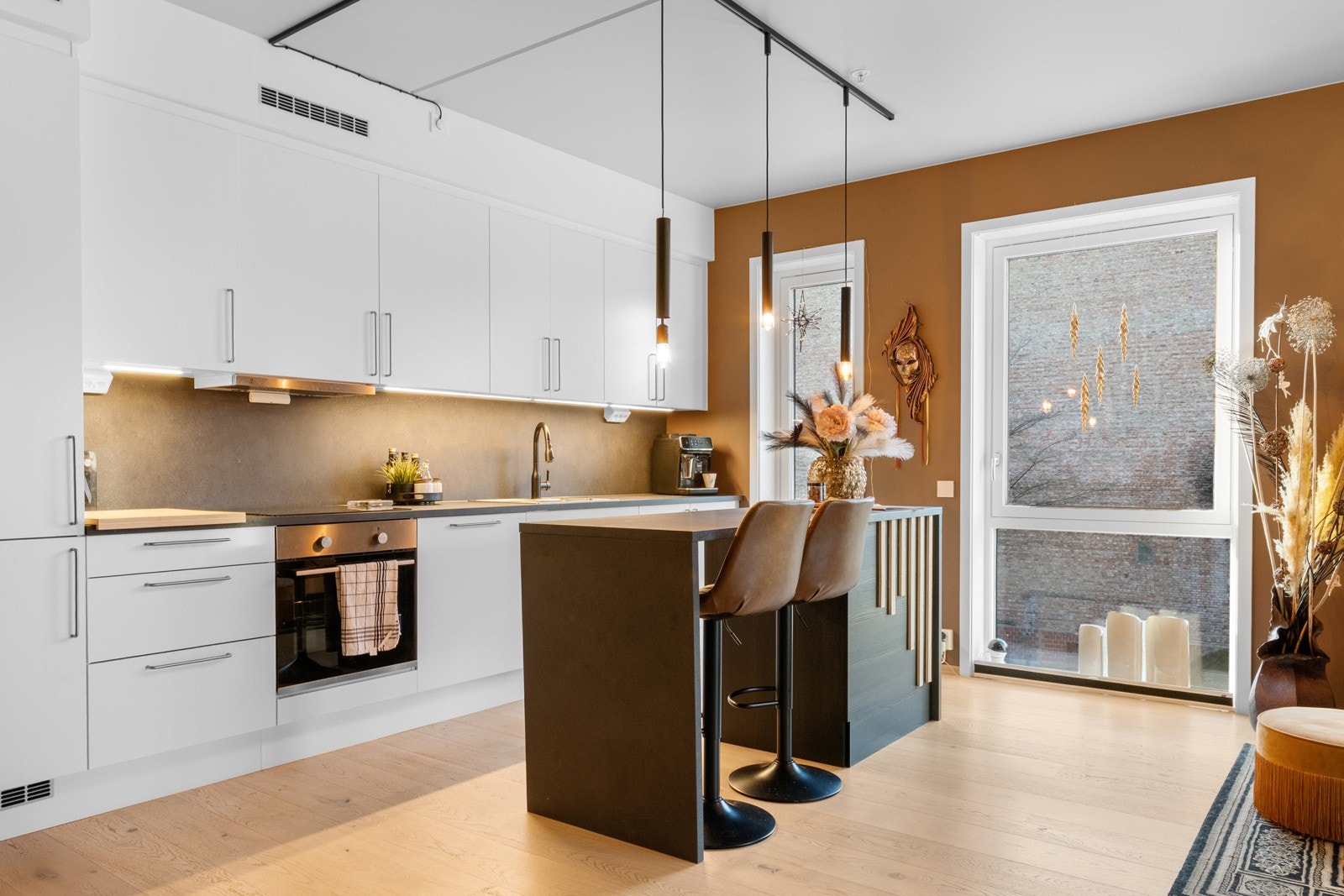 Stilrent kjøkken fra HTH med hvite, glatte fronter, laminert benkeplate og dobbel oppvaskkum i stål. Galleribilde