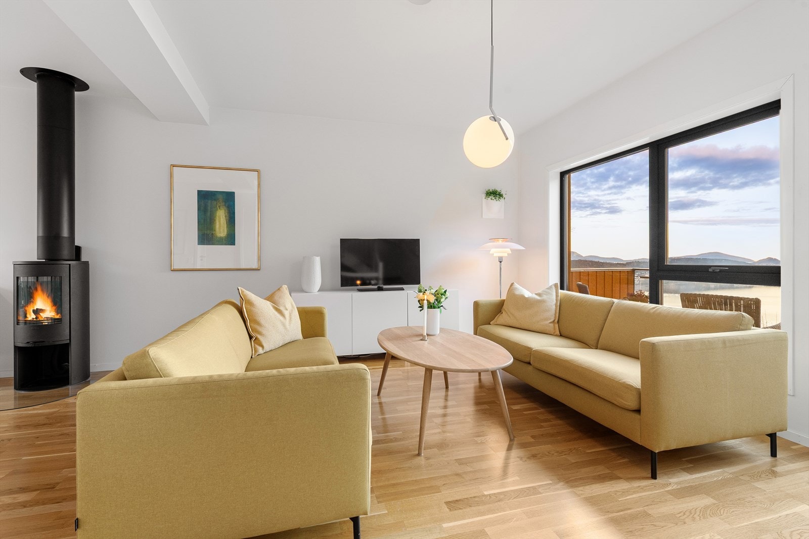 Lys og innbydende stue med peisovn. Galleribilde