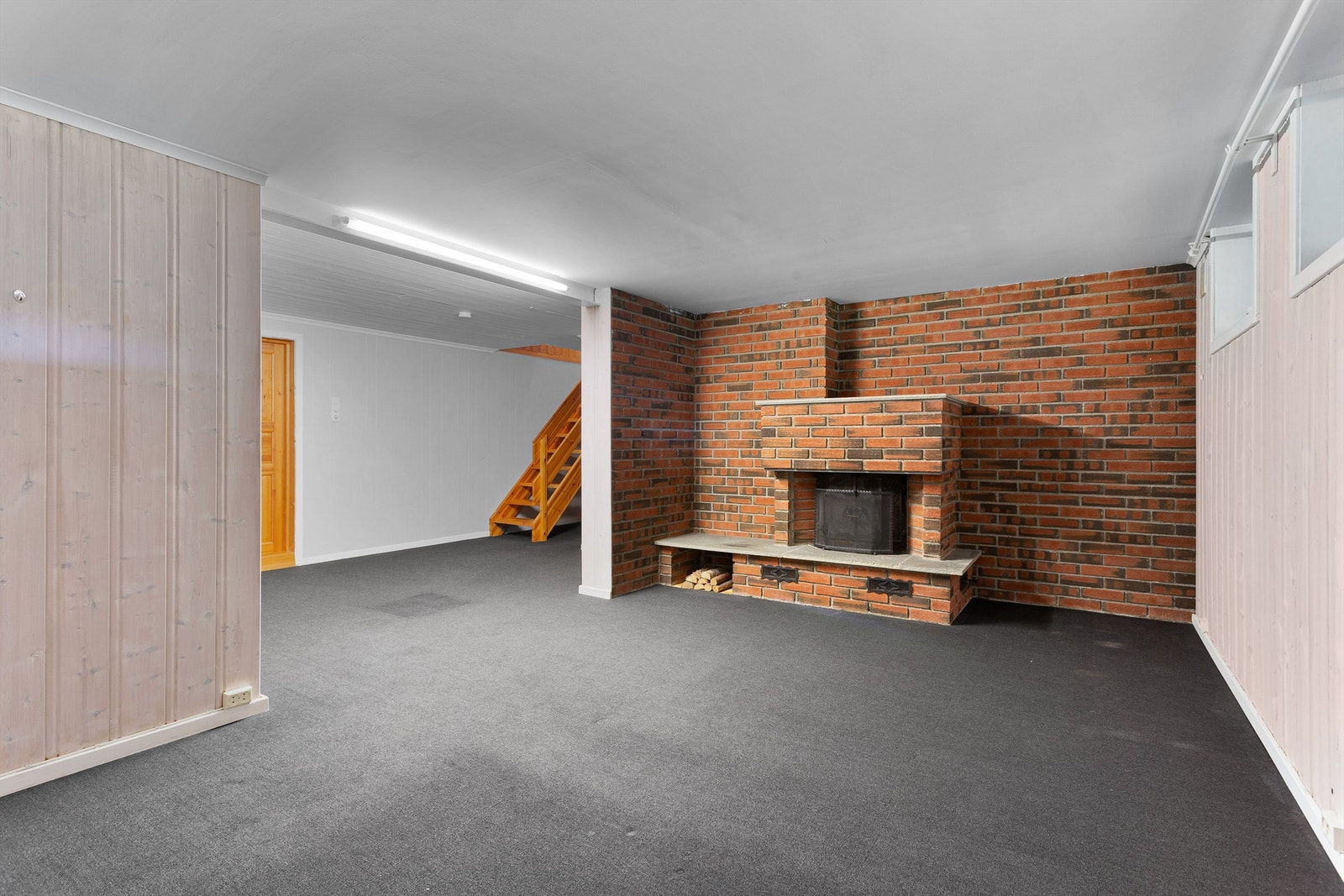 Innredet kjellerstue med innmurt peisinnsats og gulvvarme - Rommet er ikke godkjent for varig opphold Galleribilde