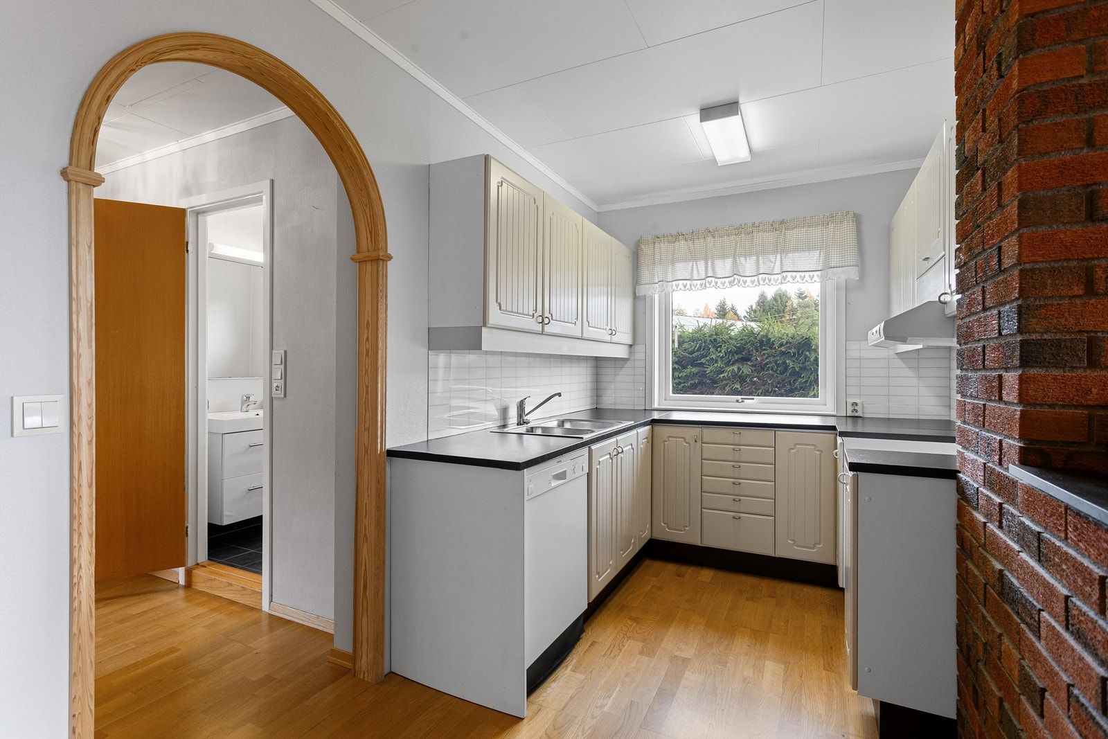 Profilert kjøkkeninnredning med over- og underskap i hvit utførelse - Utleiedel Galleribilde