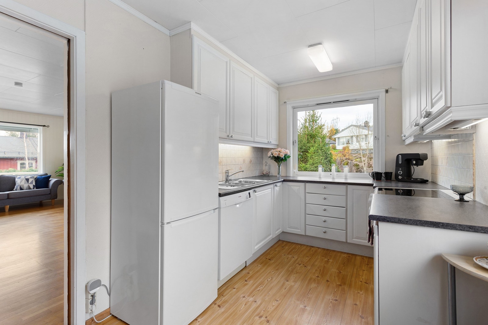 Profilert kjøkkeninnredning med over- og underskap i hvit utførelse Galleribilde