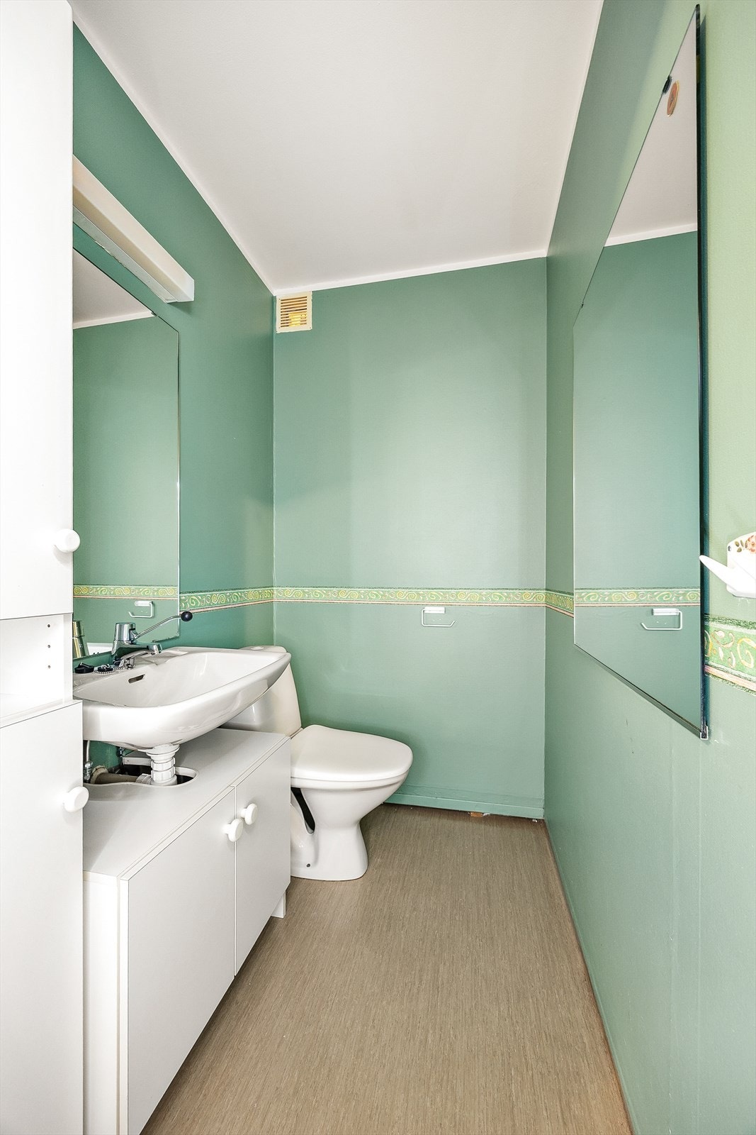 Leiligheten har et separat toalettrom med servant og vinylbelegg på gulvet. Galleribilde