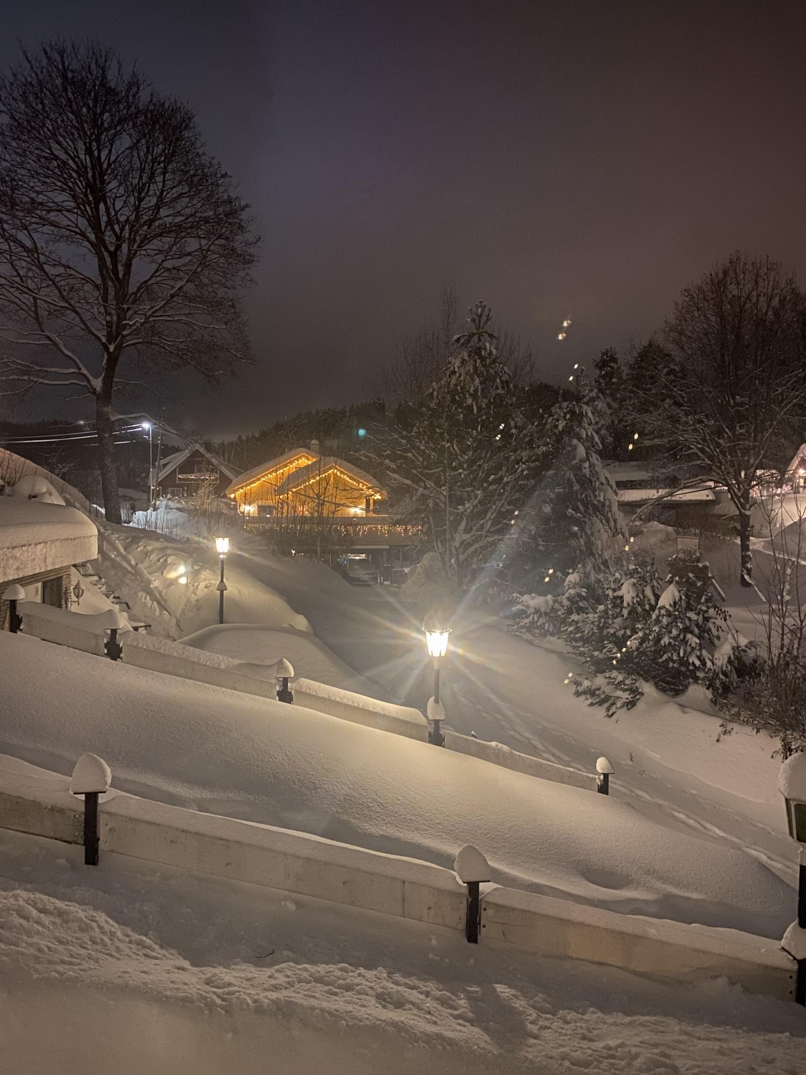Fredelig kveldsstemning med snø, lys og stille nabolag. Galleribilde