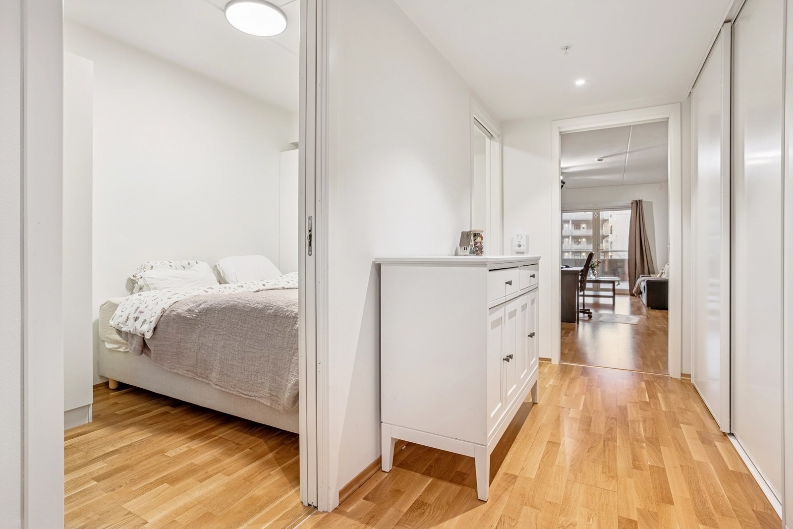 Fra entreen har du praktisk tilgang til et romslig skyvegarderobeskap på høyre side, perfekt for oppbevaring av yttertøy og sko. Dette gir en ryddig og funksjonell entré med god plass til organisering. Galleribilde