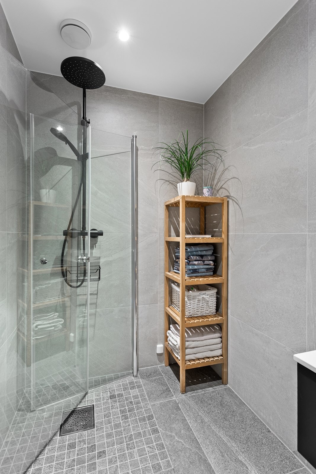 Bad 1 med dusjhjørne med glassdører og vegghengt toalett Galleribilde