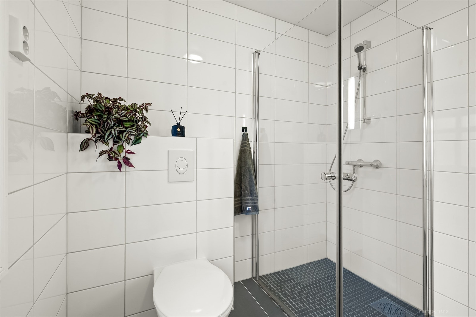 Badet har dusjhjørne med foldedører av glass og gulvvarme Galleribilde