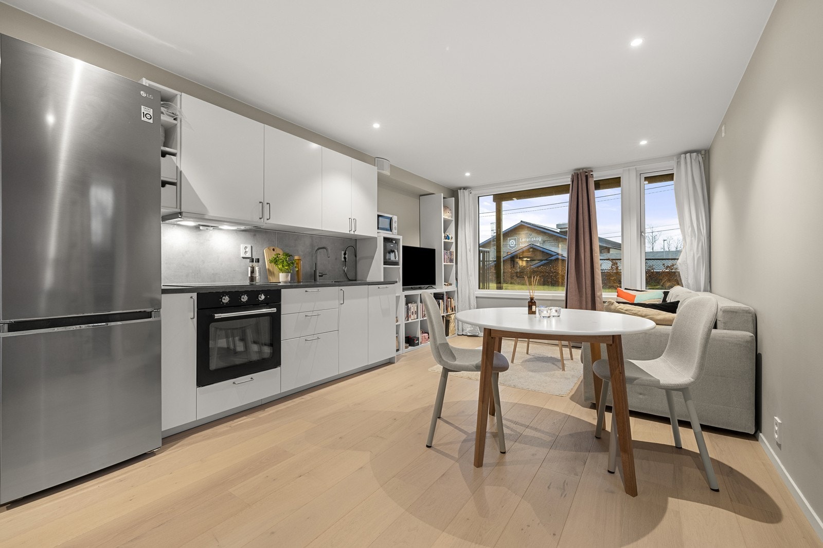 Kjøkkenet har en moderne innredning med glatte fronter, laminatbenkeplate og integrert oppvaskmaskin, komfyr og platetopp. Galleribilde