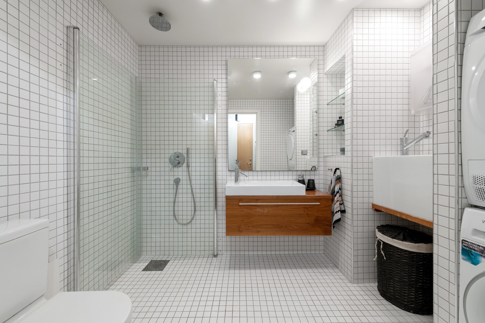 Flislagt bad med dusjnisje, toalett, utslagsvask og opplegg for vaskemaskin og tørketrommel Galleribilde