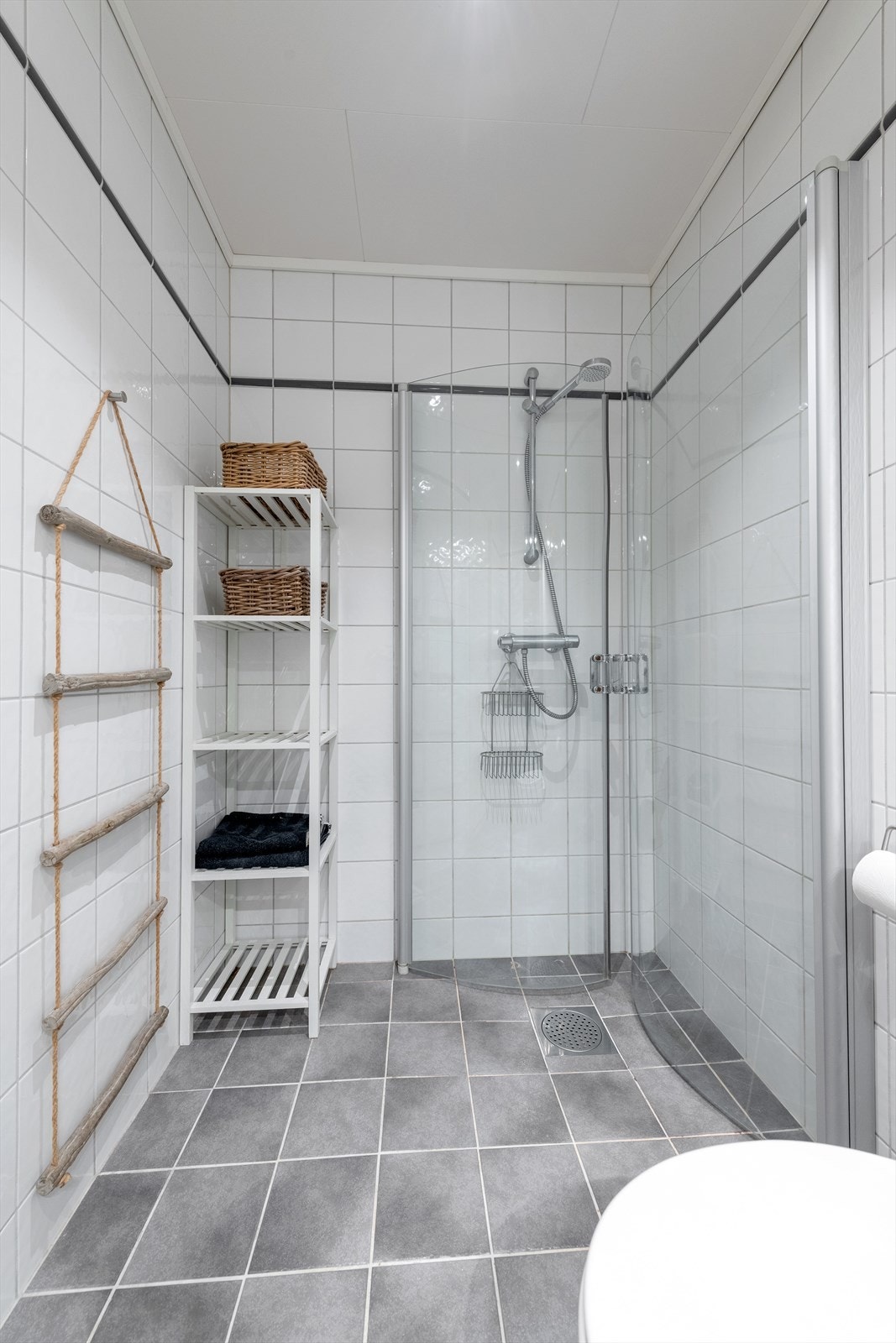 Dusjhjørne med foldbare glassvegger og vegghengt dusjarmatur på bad Galleribilde