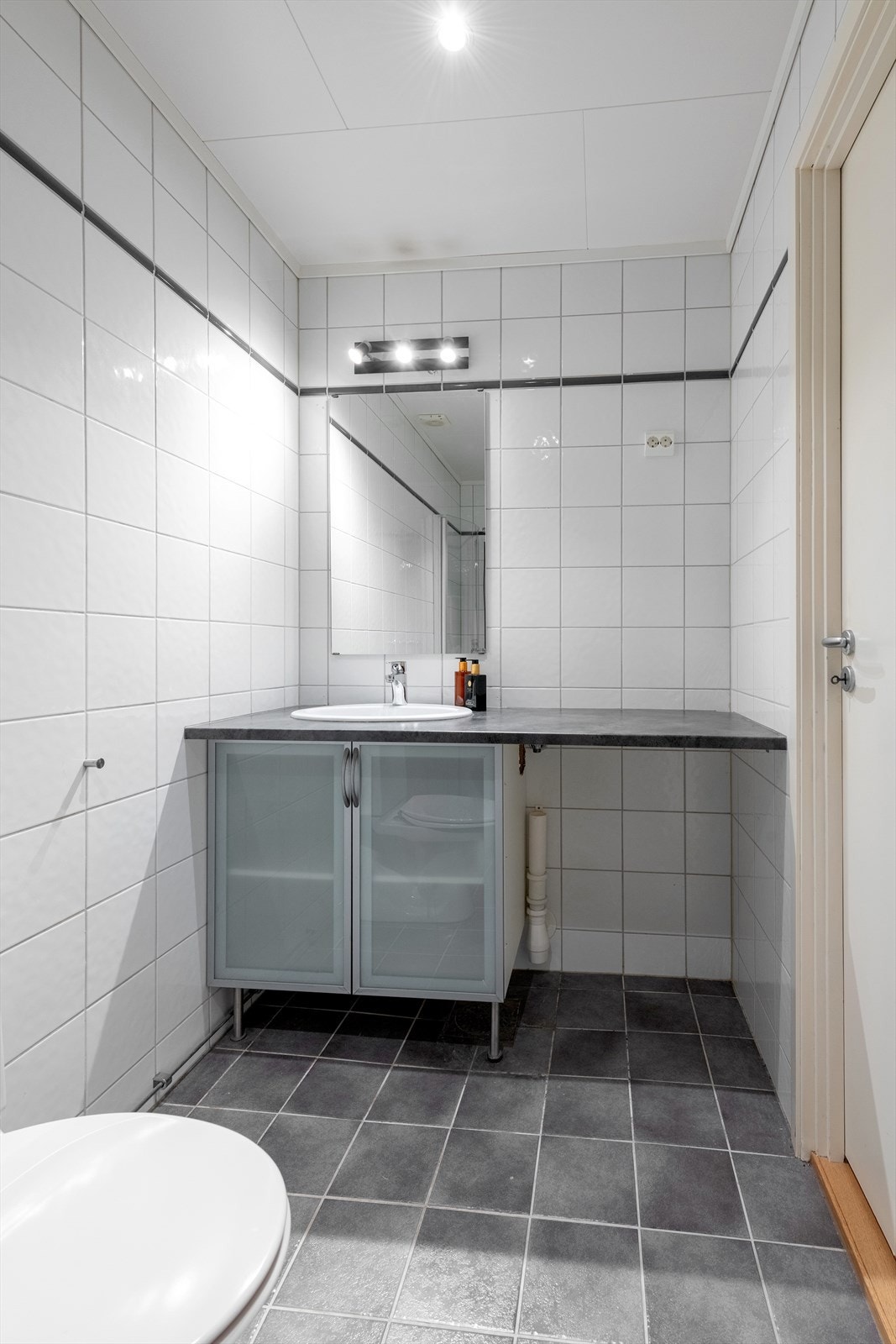 Baderomsinnredning med god benkeplate og opplegg for vaskemaskin under Galleribilde