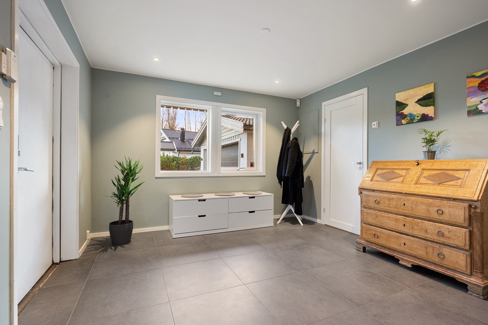 En romslig hall med flislagt gulv og elektriske varmekabler ønsker velkommen inn. Galleribilde