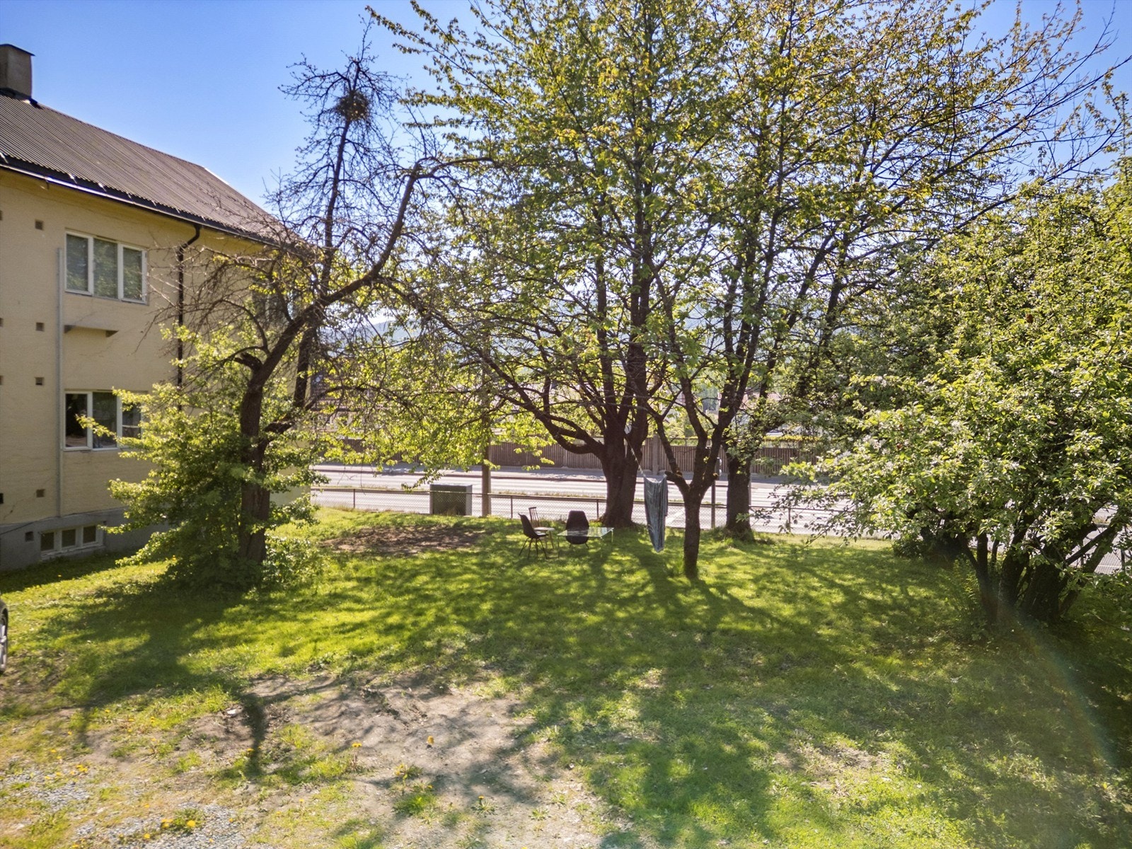 Sameiet har felles gruset gårdsplass og stort felles hageområde Galleribilde