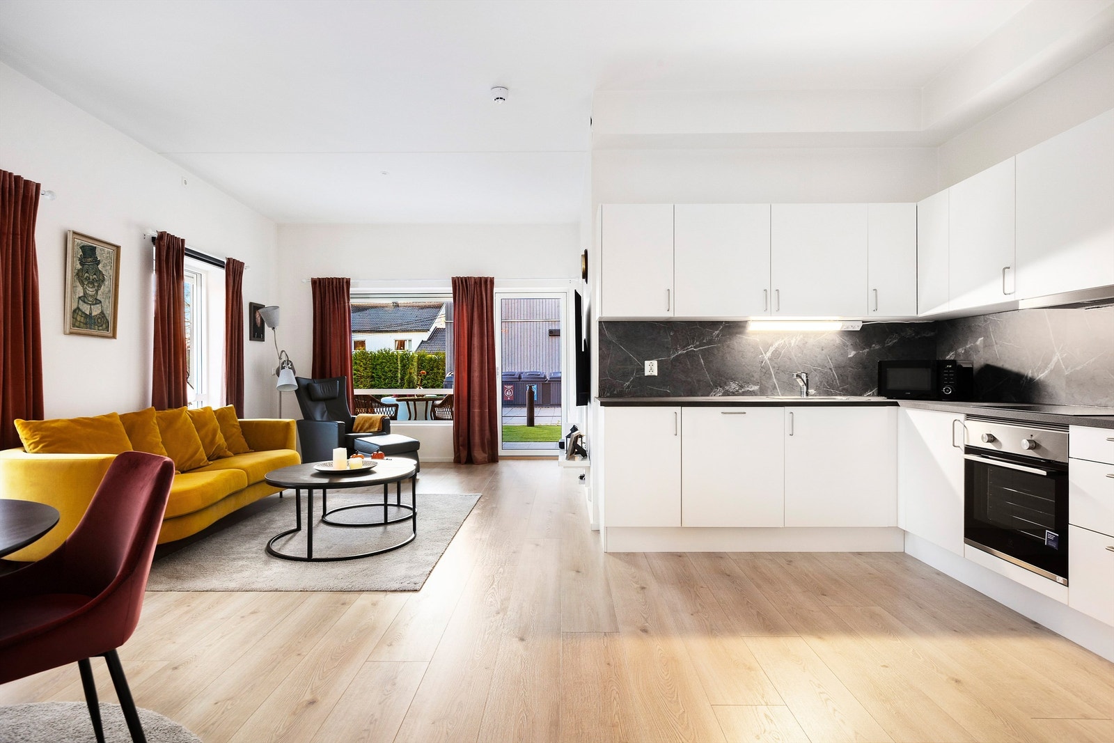 Åpen kjøkken- og stueløsning med godt utnyttet skap - og benkplass. Kjøkkenet er fra HTH med glatte hvite fronter. Laminat mellom overskap og benk Galleribilde