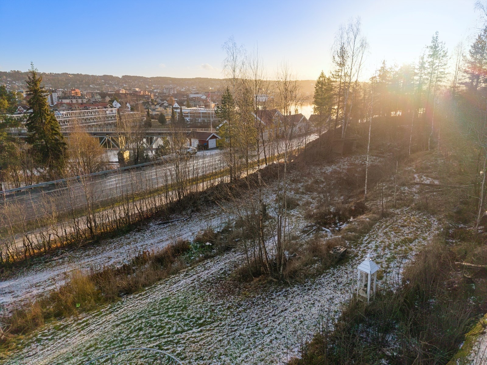 Tomten er skrående og består av gress, beplantninger og stein. Galleribilde