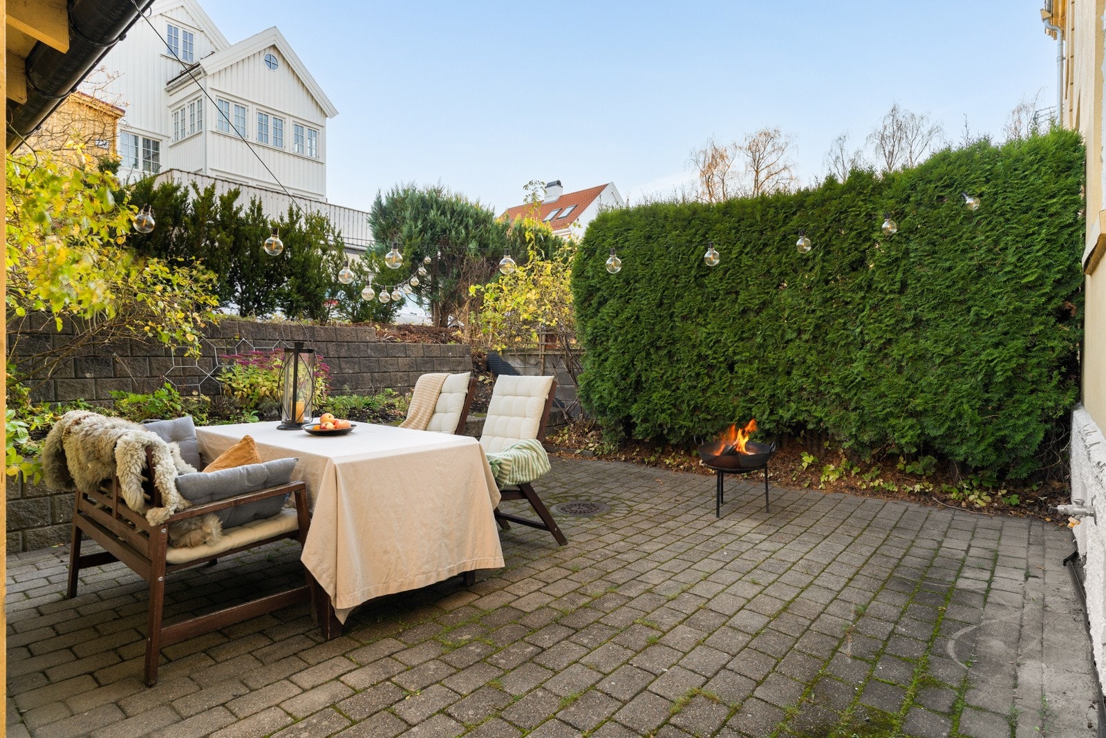 Baksiden av boligen har et usjenert og steinbelagt uteområde som kan benyttes til koselige stunder hele året. Galleribilde