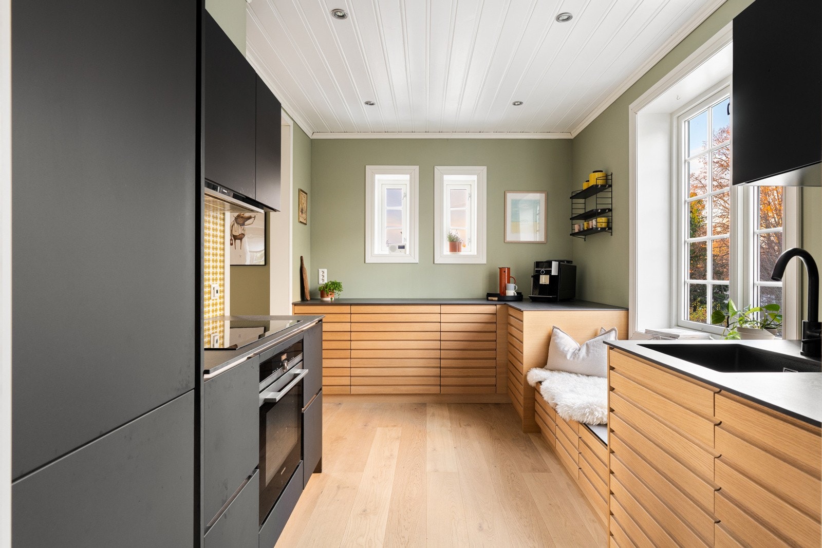 Kjøkkenet kombinerer stilrene materialer med smarte og gjennomtenkte oppbevaringsløsninger. Galleribilde