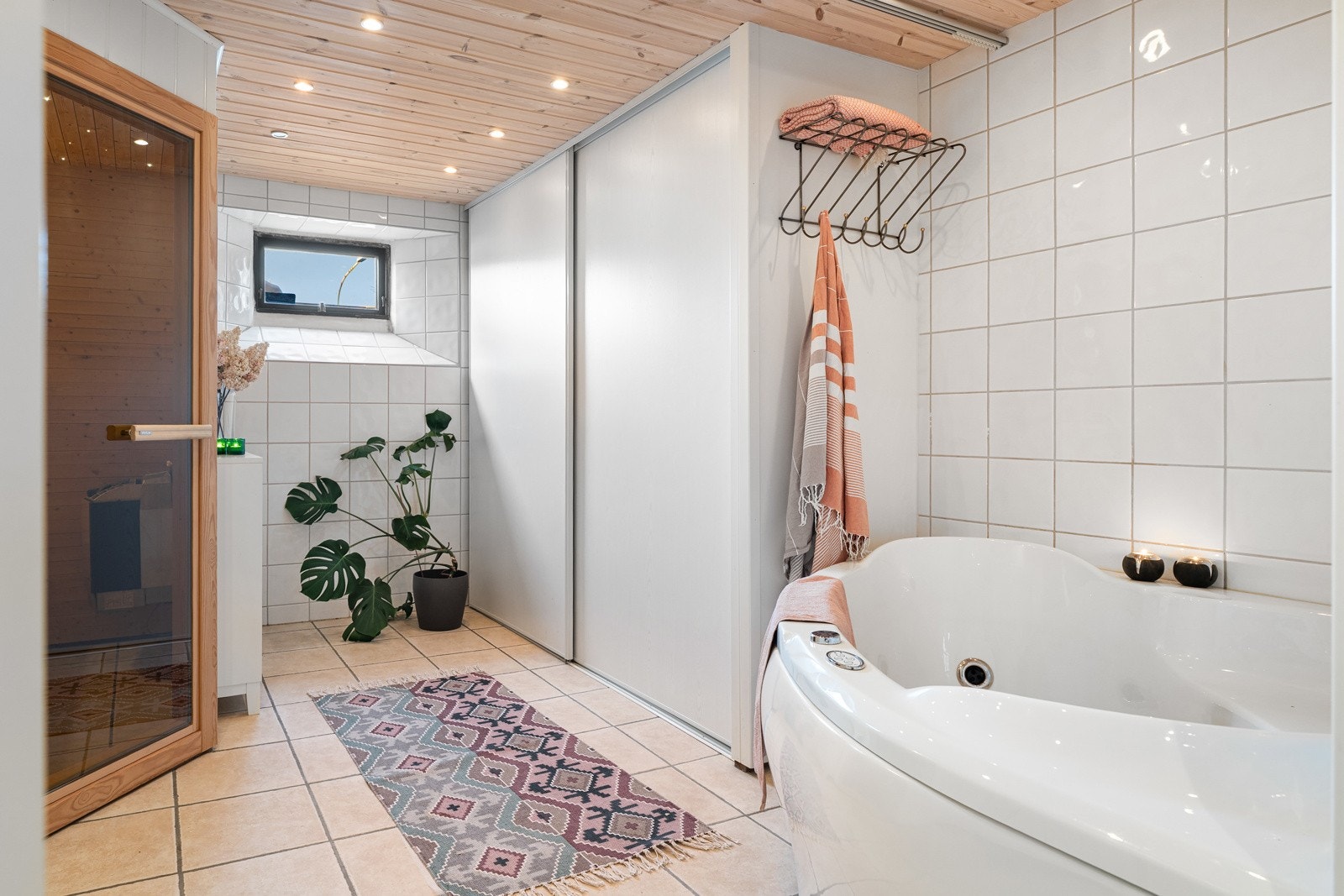 Flislagt baderom med downlights i himling, et stort boblebad, badstu og rikelig med oppbevaringsplass. Galleribilde