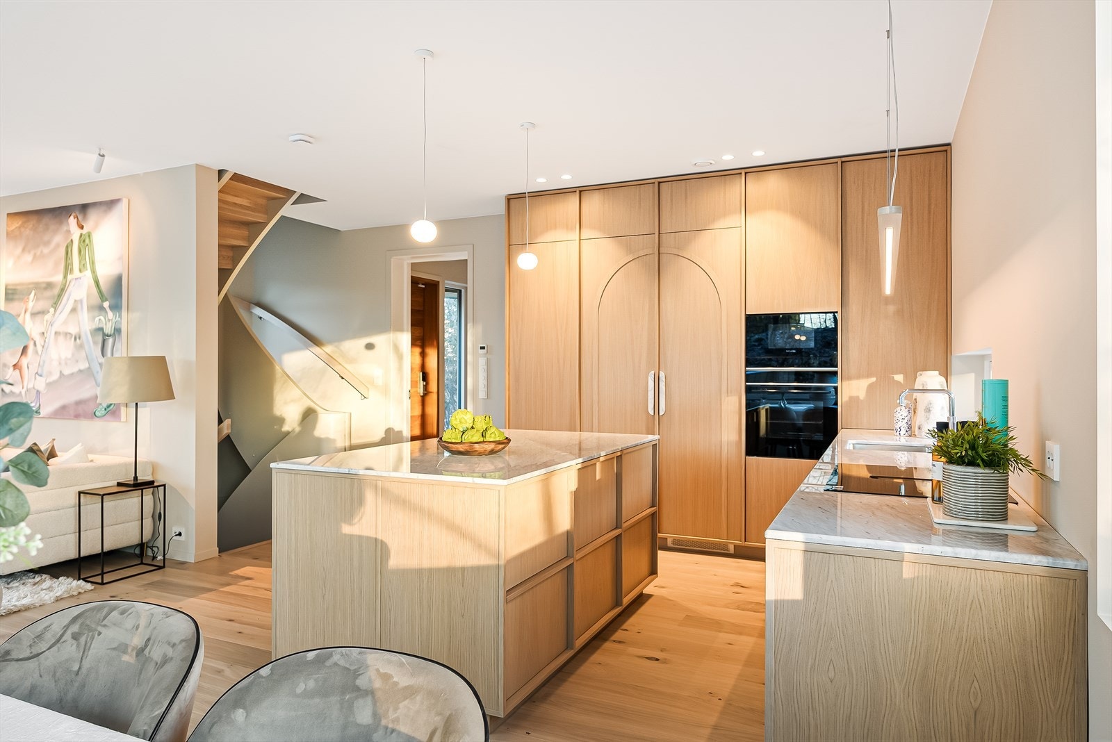 Flos belysning over kjøkkenøy, integrerte hvitevarer fra Siemens og marmor benkeplate. Mange av de detaljene i boligen er nøysommelig utført Galleribilde