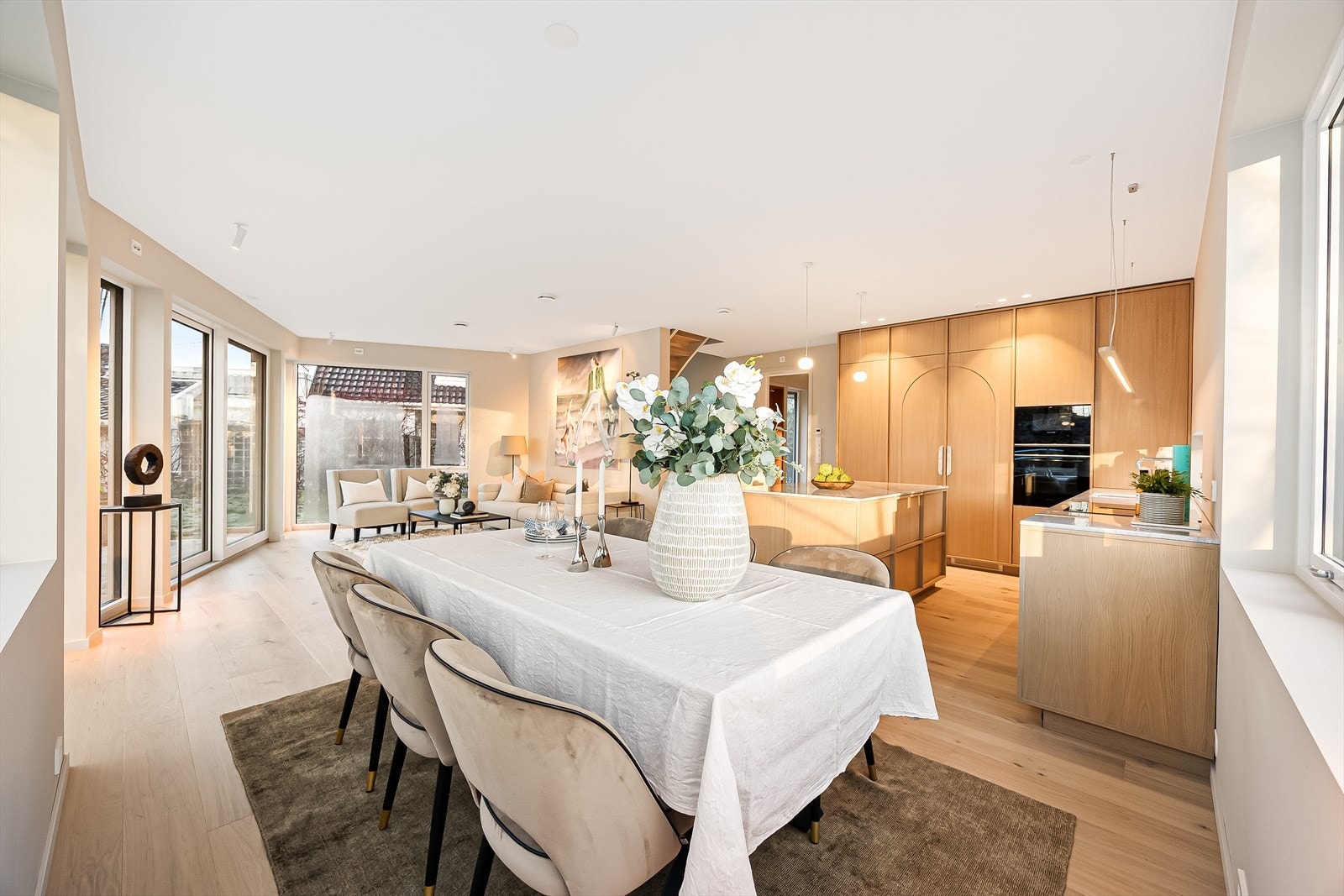 Meget stor og flott stue i åpen løsning til kjøkken av høy kvalitet. Legg merke til rikelig belysning i himling Galleribilde