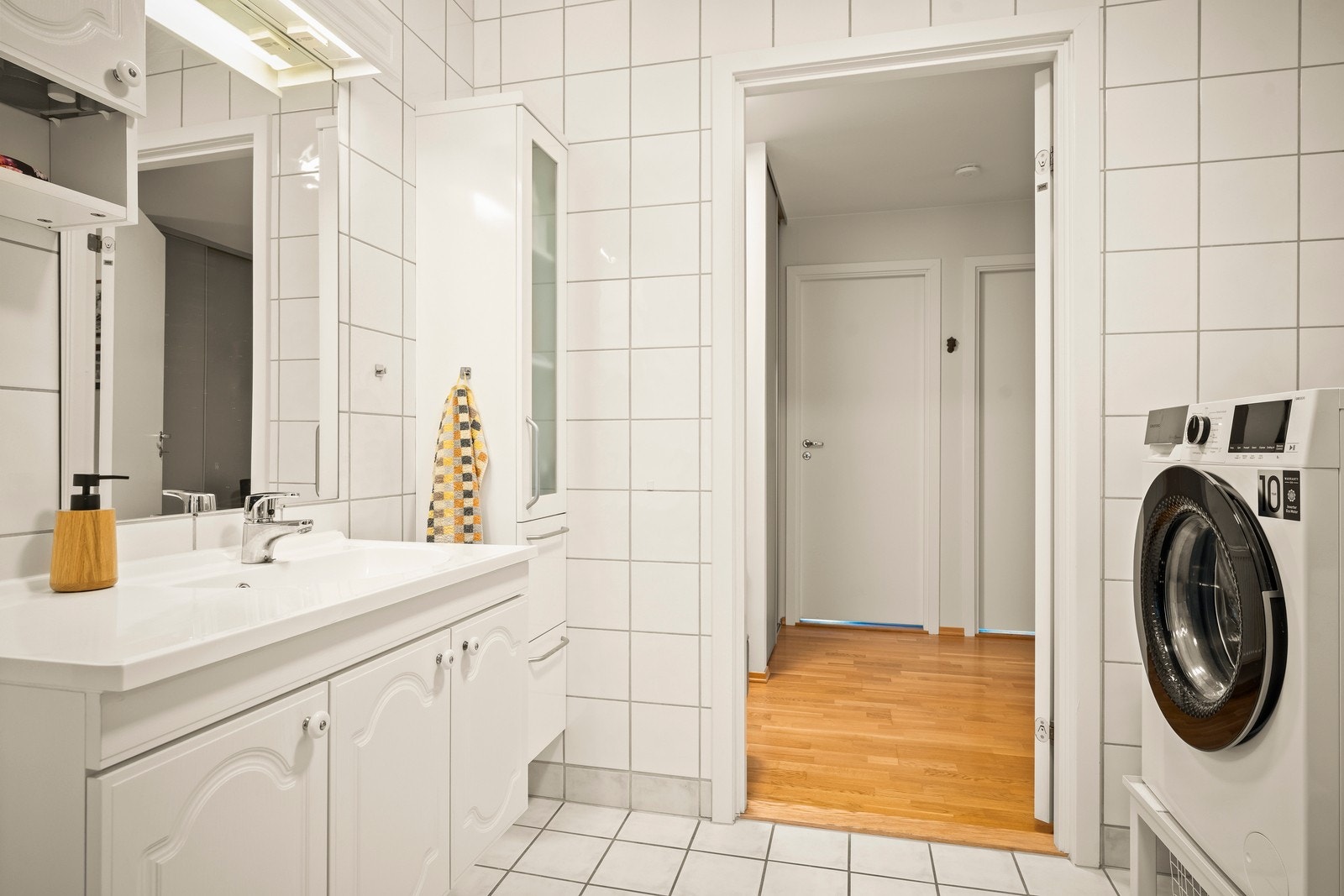 Gulvstående toalett og opplegg for vaskemaskin. Rommet har elektriske varmekabler i gulvet og lyspunkt i himlingen. Badet ventileres via ventil som er tilkoblet mekanisk avtrekk. Galleribilde