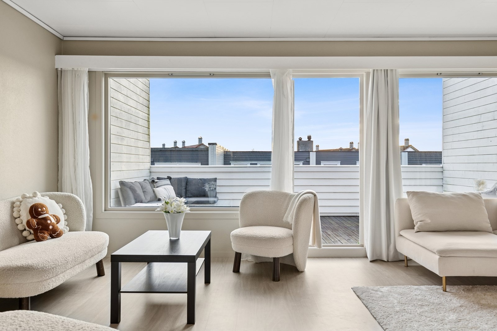 Lys og romslig stue med tidsriktige farger og store vindusflater. Praktisk utgang til terrasse gir en fin overgang mellom inne- og uteområder. Galleribilde