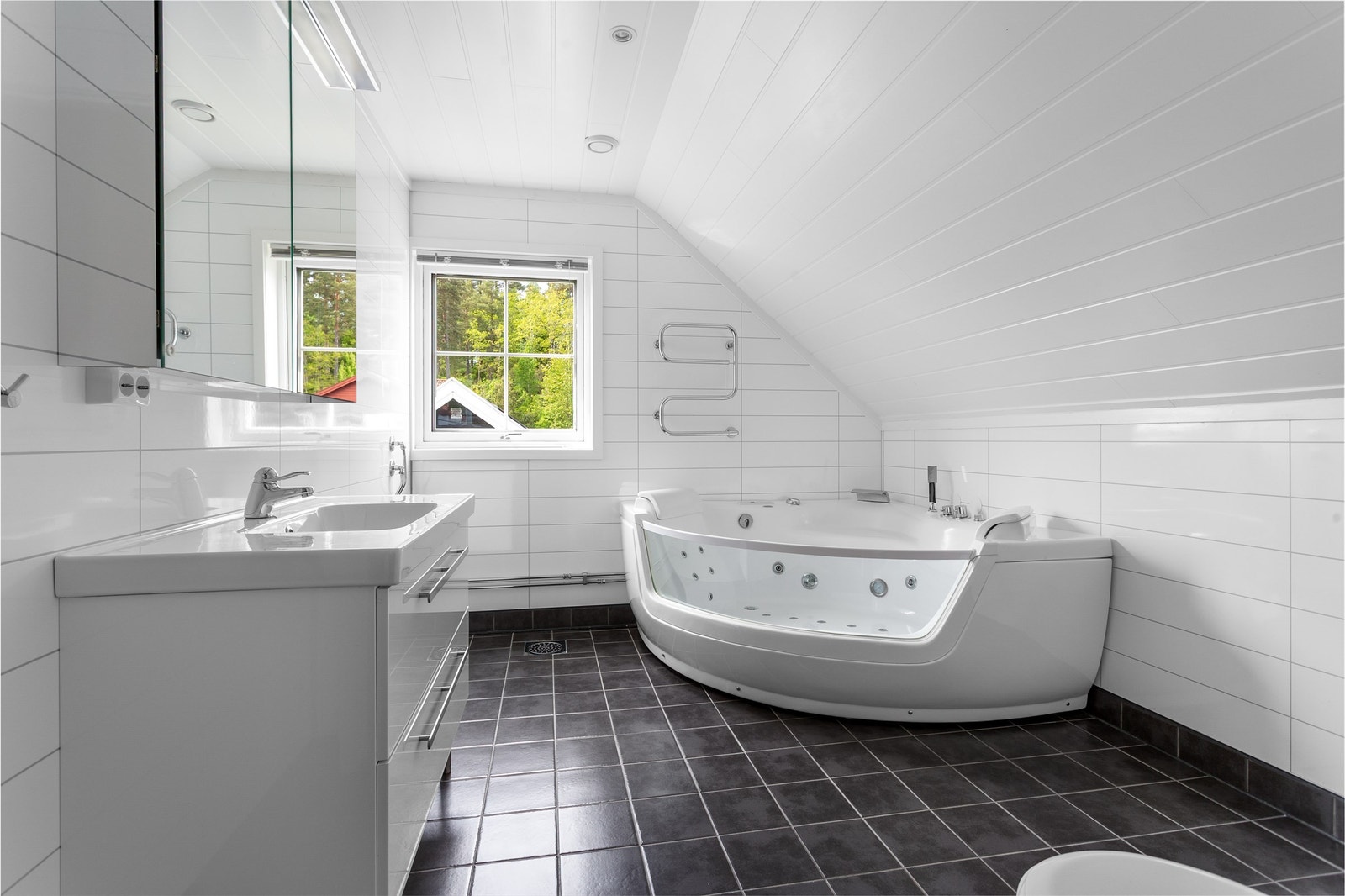 Badet har hjørneboblebadekar med massasjedyser Galleribilde