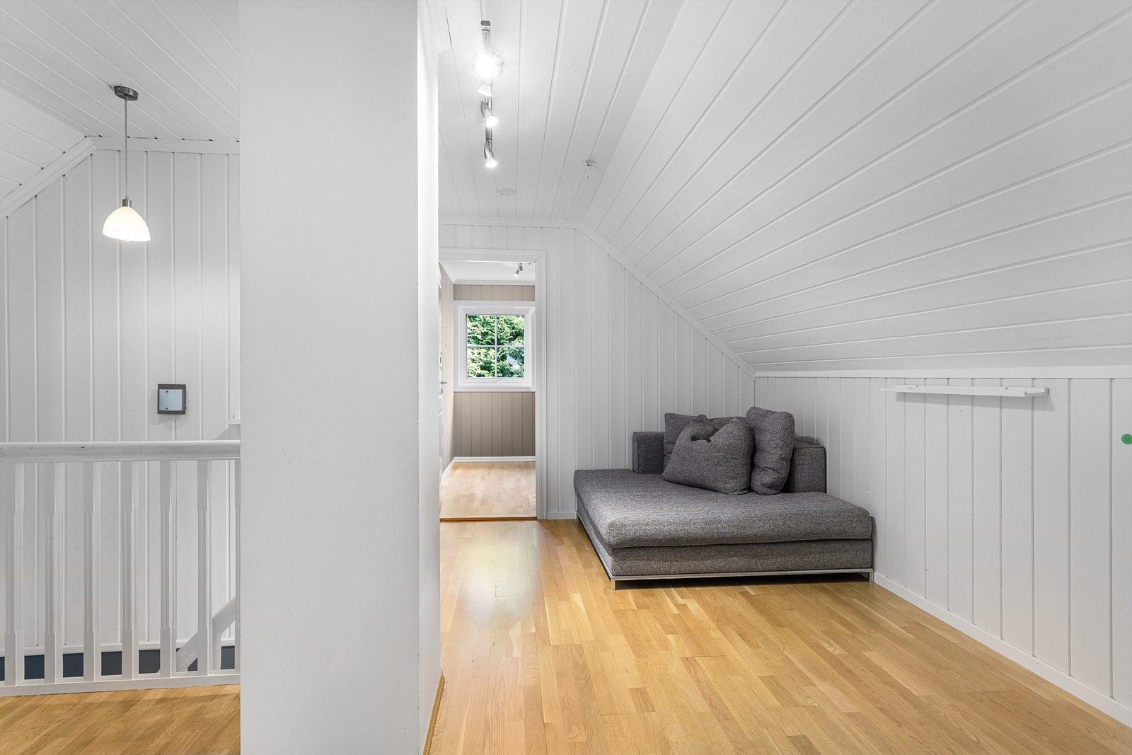 Loftstue med parkett på gulv, malt panel på vegger og malt panel i himling Galleribilde