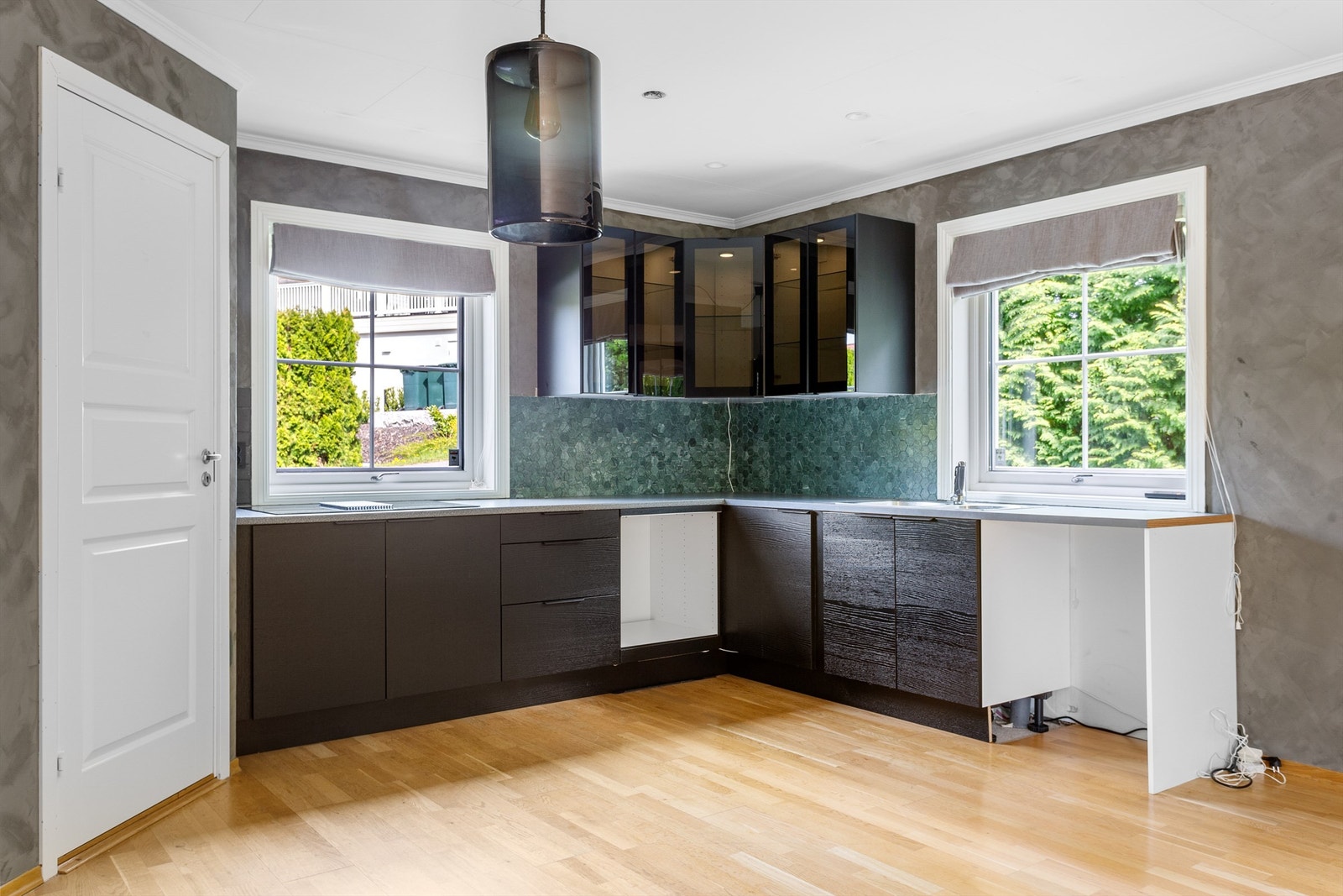 Pen kjøkkeninnredning med integrert platetopp som har nedfelt ventilator Galleribilde