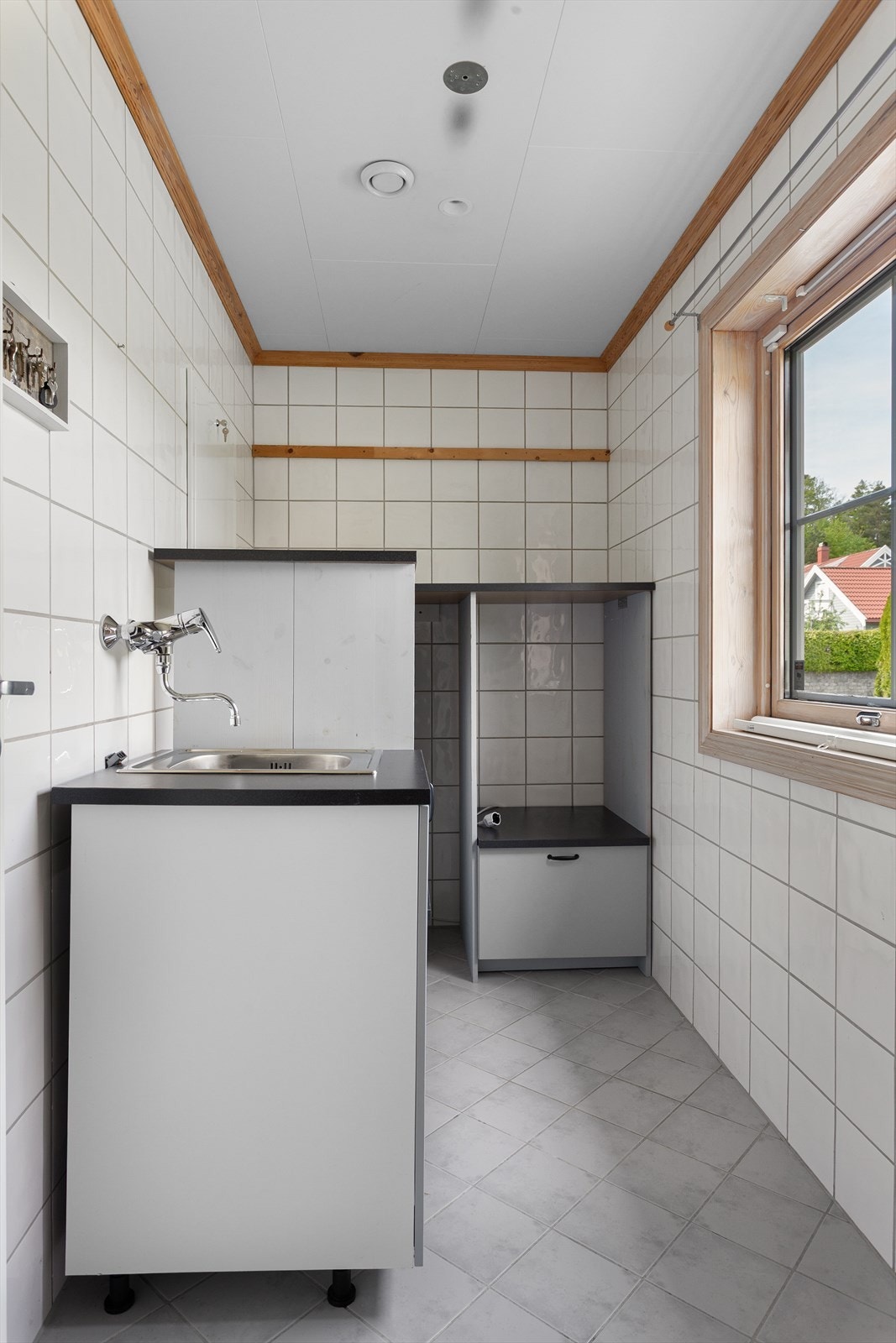 Separat vaskerom med nedfelt utslagsvask og skapinnredning Galleribilde