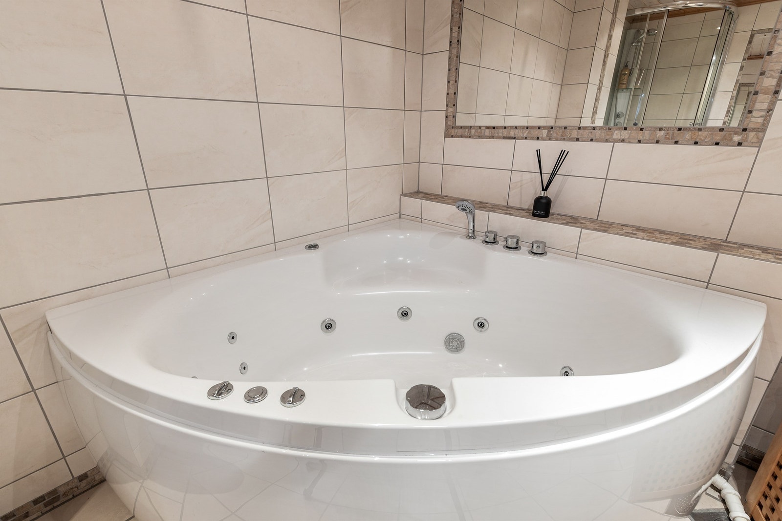 Badet har hjørneboblebadekar med hånddusj Galleribilde