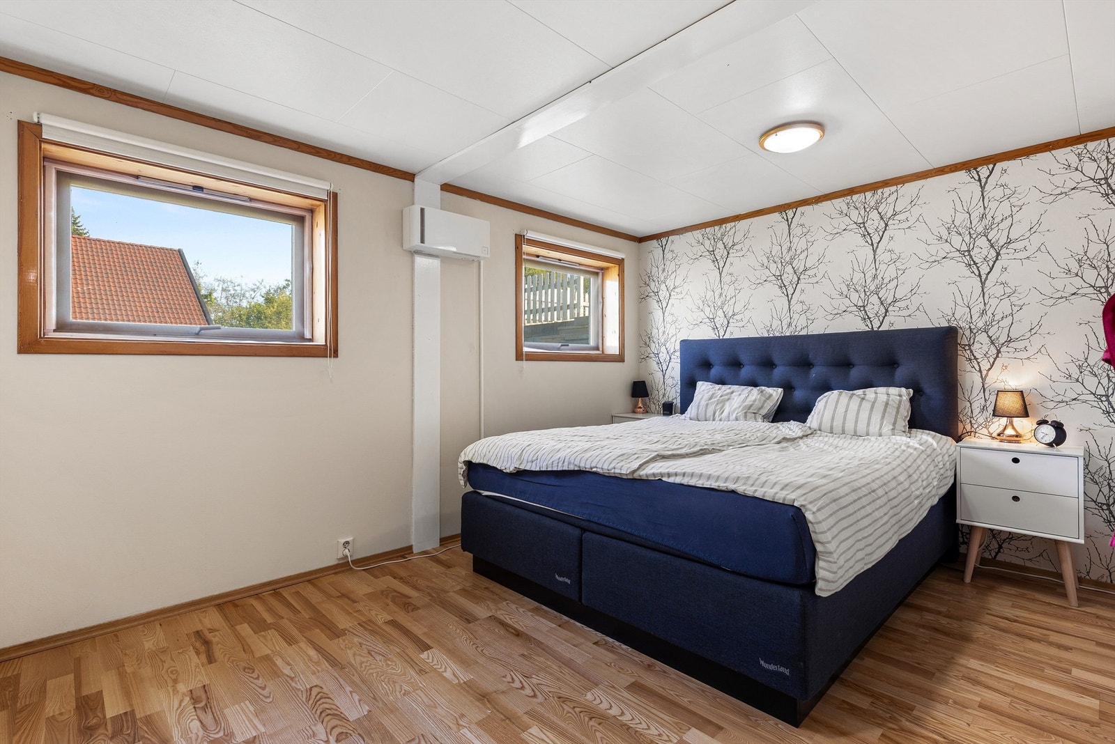 Soverom med 3-stavs parkett på gulv, tapet samt malte vegger og plater i himling Galleribilde