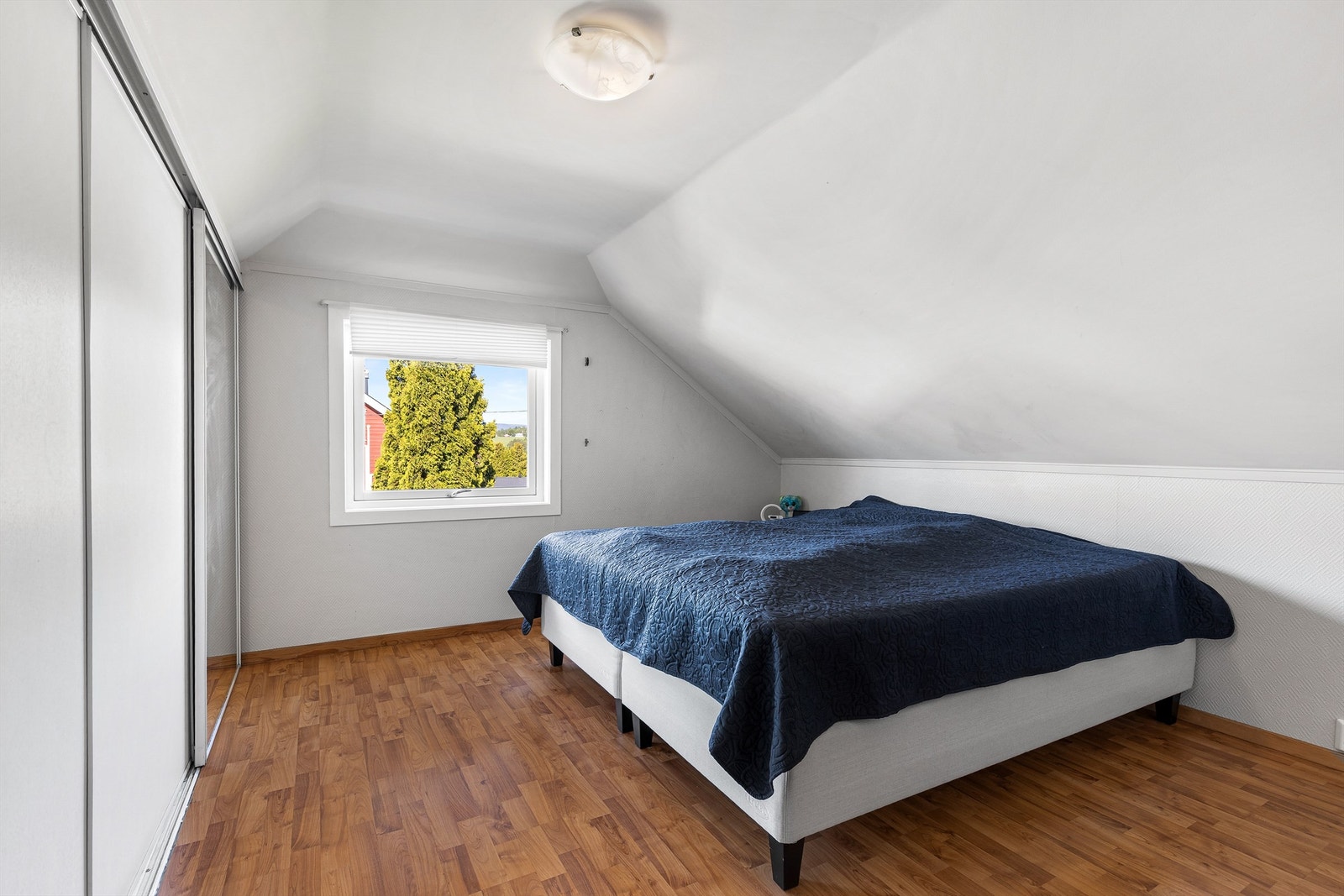 Soverom med 3-stavs parkett på gulv, tapet på vegger og malt himling Galleribilde