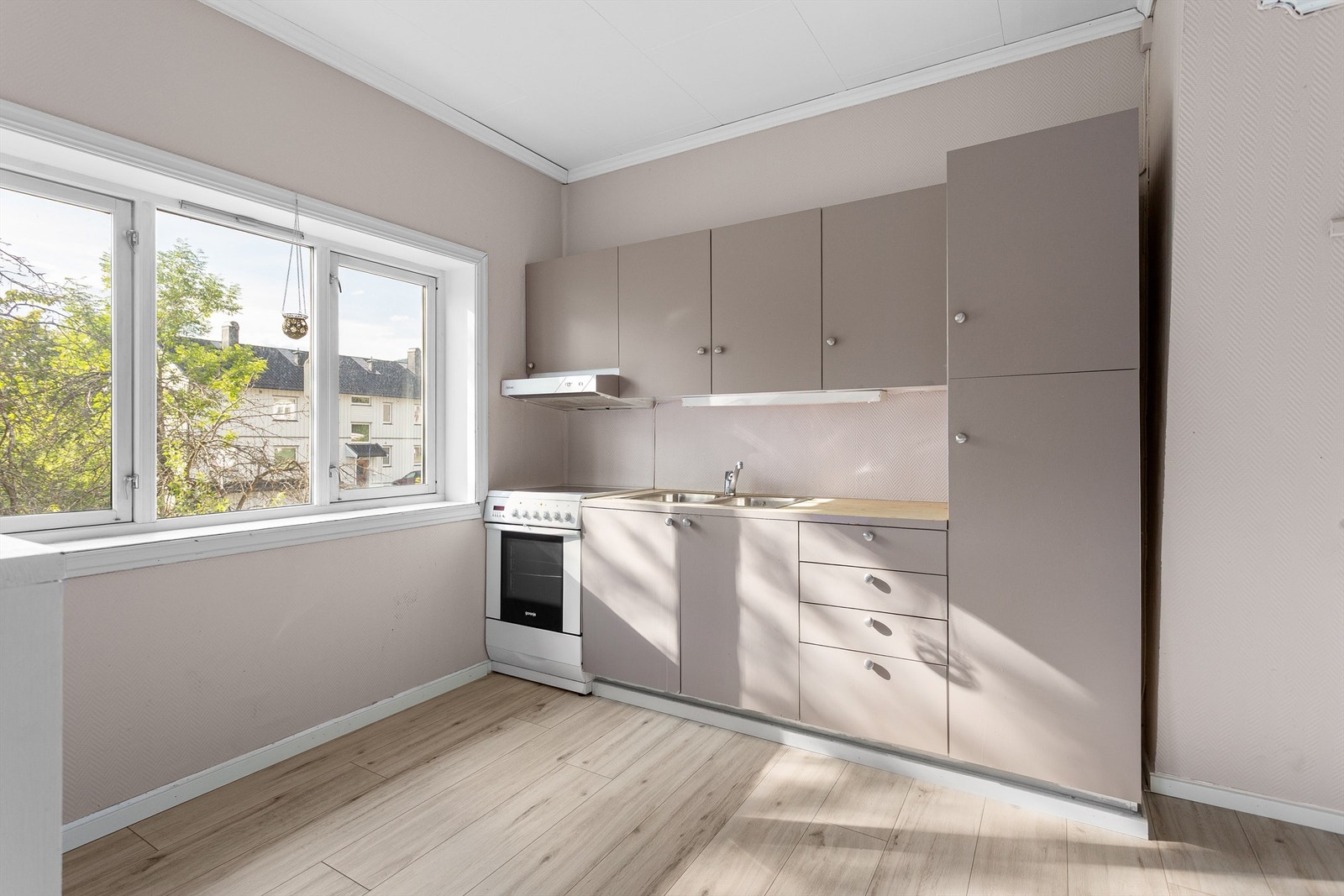 Kjøkkeninnredning med over- og underskap samt høyskap i glatt utførelse Galleribilde