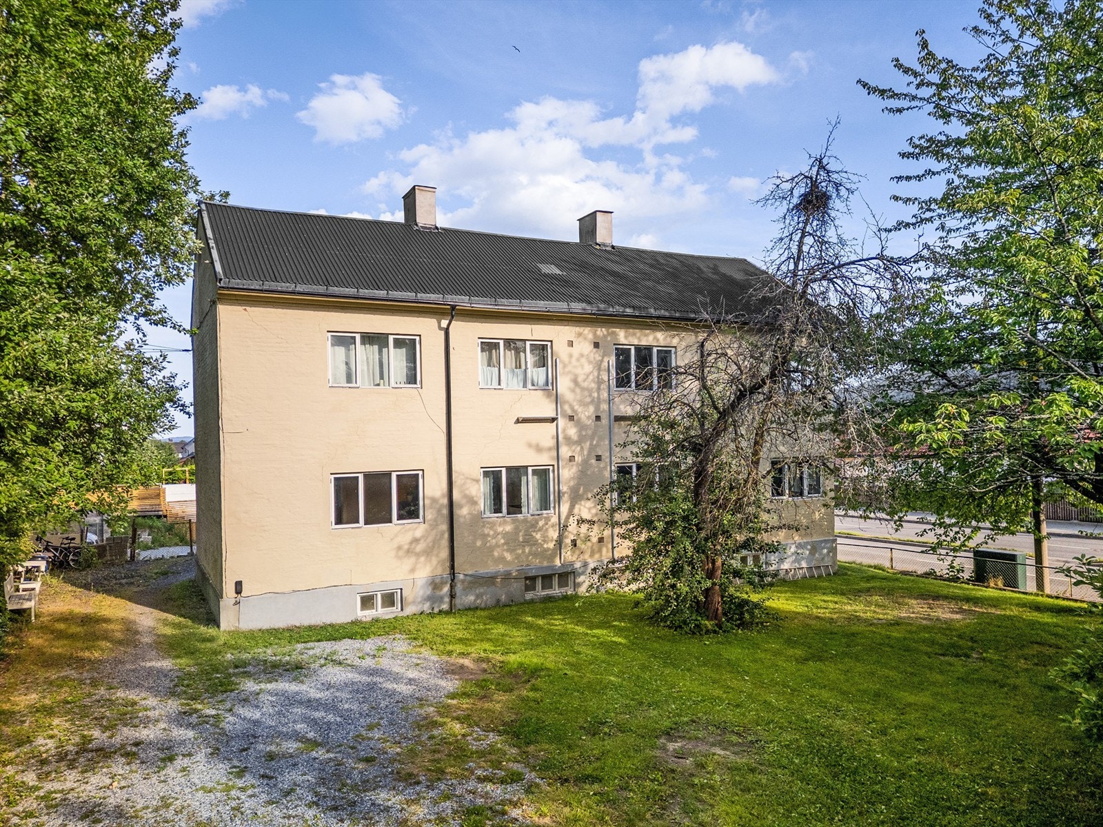 Sameiet har felles gruset gårdsplass og stort felles hageområde Galleribilde