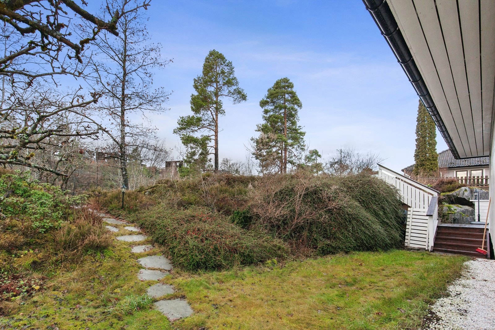 Eiet tomt skrånende mot øst med vestvendt hage og god solgang. Eiendommen er godt opparbeidet med plenarealer, beplantninger, trær og steinlagt gårdsplass. Galleribilde