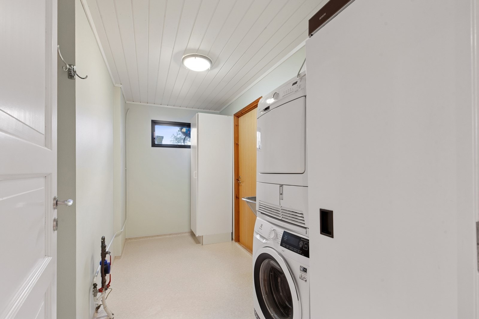 Praktisk vaskerom i underetasjen fra byggeåret. Videre tilgang til en av de to bod-rommene i underetasjen. Galleribilde