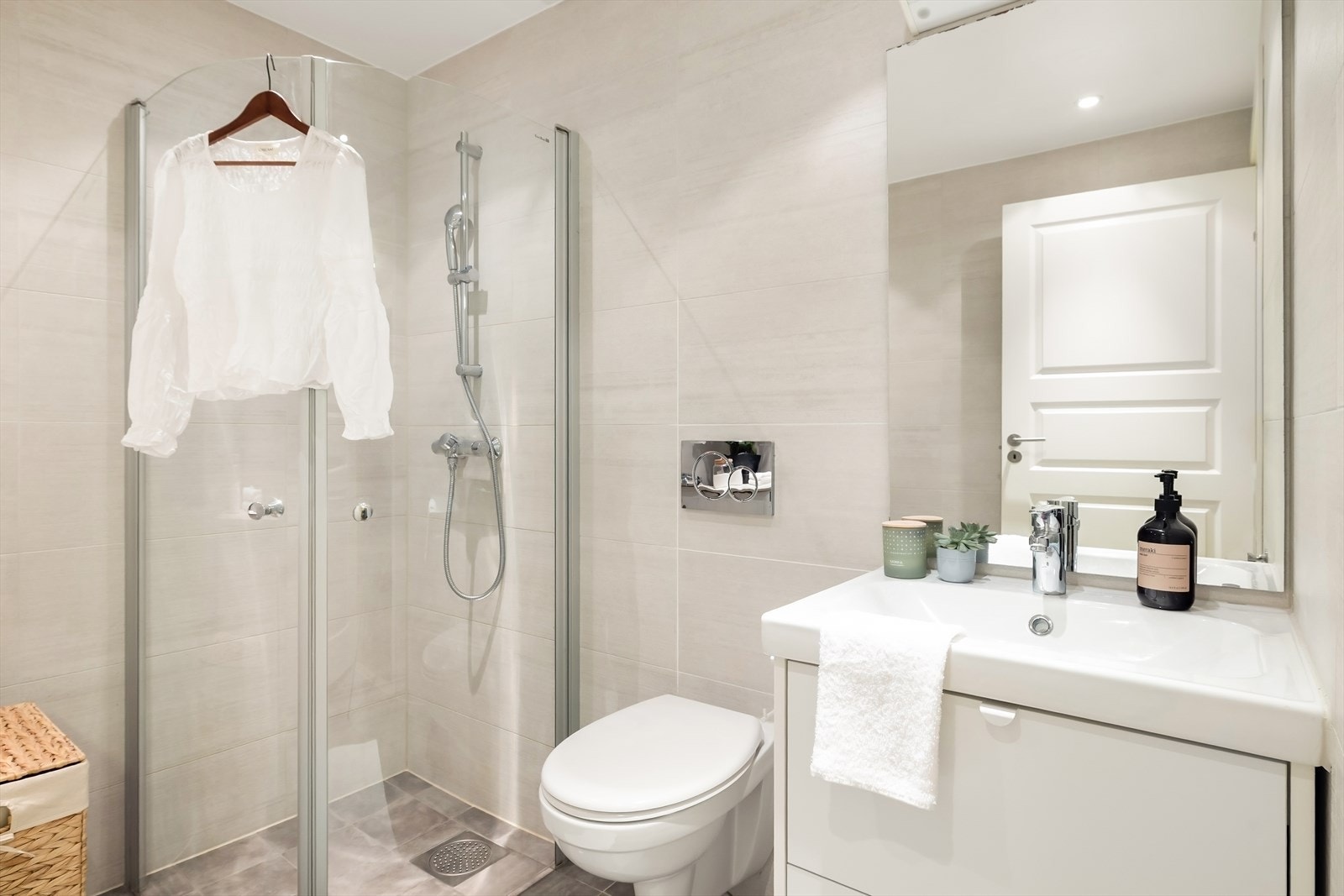 Badet er innredet med vegghengt toalett, servant i møbel, dusjhjørne og har opplegg for vaskemaskin/tørketrommel. Galleribilde