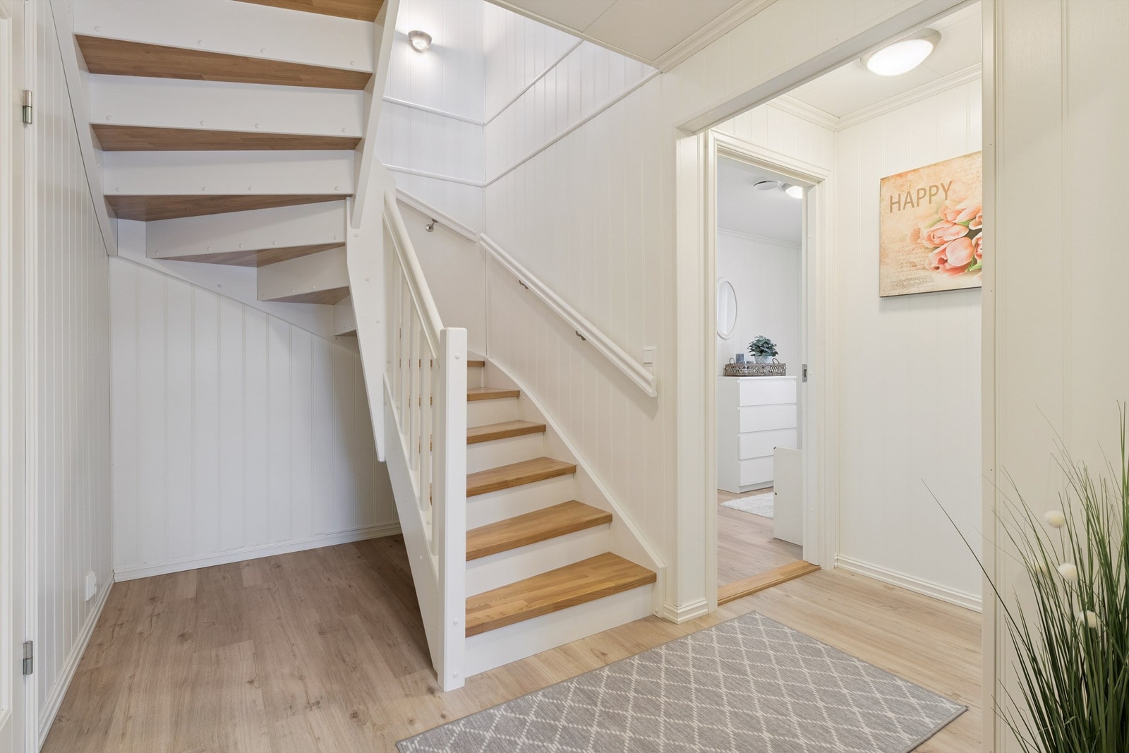 En solid, malt tretrapp med eiketrinn leder ned til boligens underetasje. Galleribilde