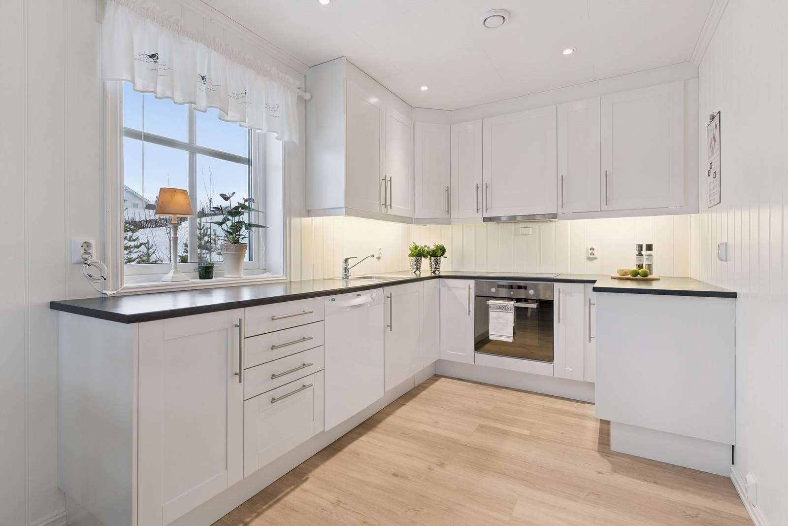 Kjøkkeninnredning i en praktisk U-form med integrert stekeovn, koketopp og oppvaskmaskin. Galleribilde