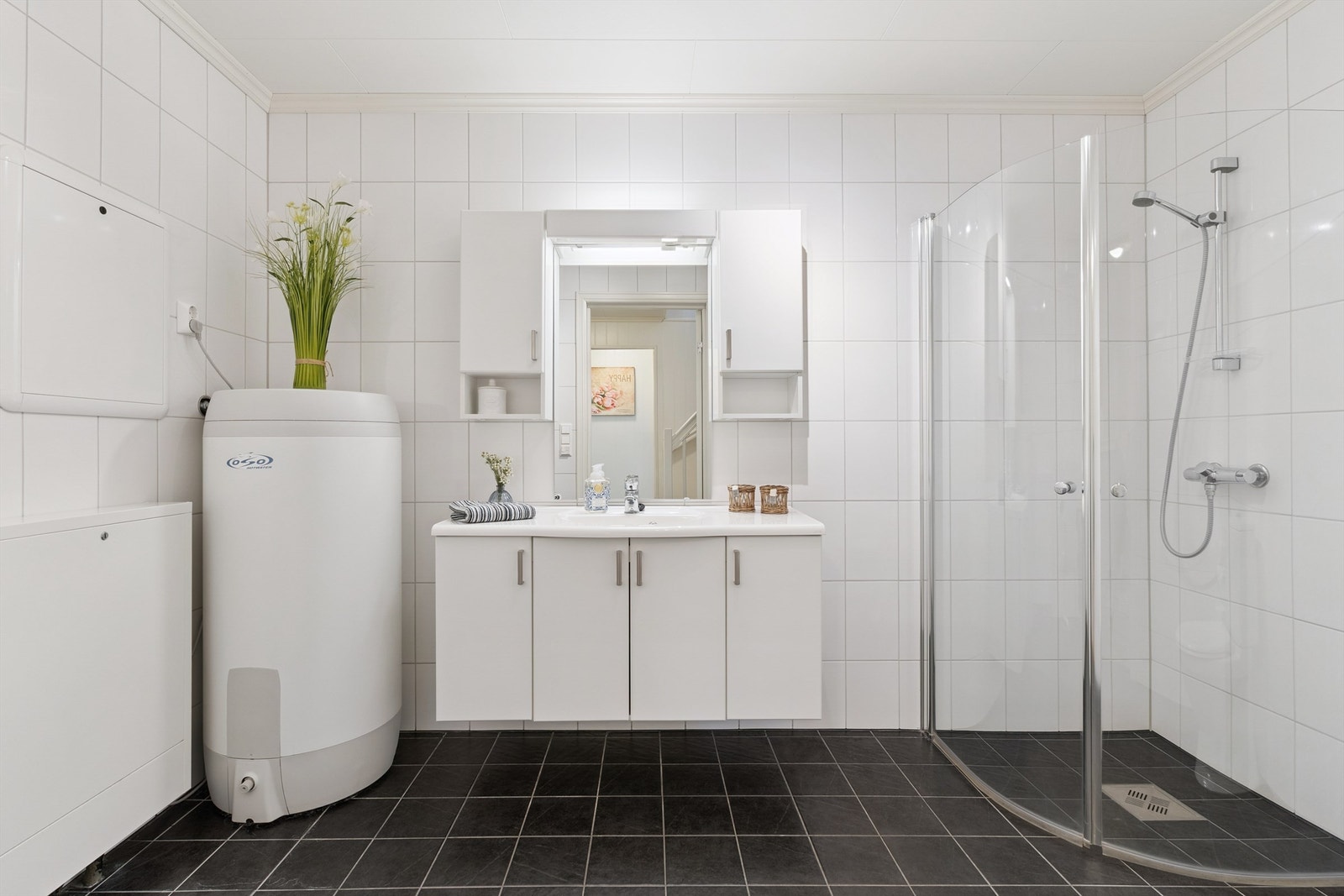 Badet er utstyrt med dusjhjørne, toalett, servantinnredning og opplegg for vaskemaskin. Galleribilde