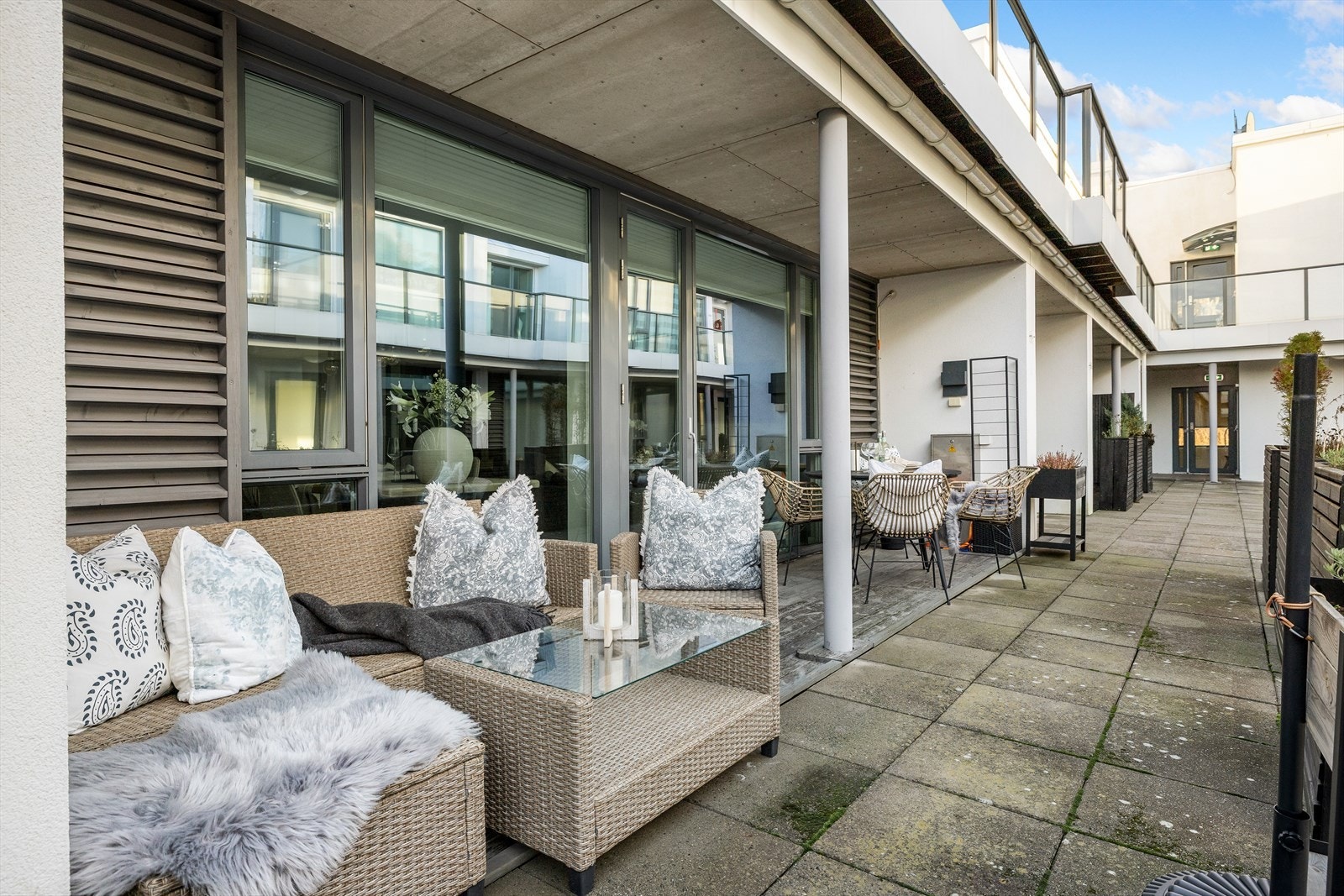 Koselig, overbygget uteplass på bakkeplan med plass til både sittegruppe og spisebord. Galleribilde